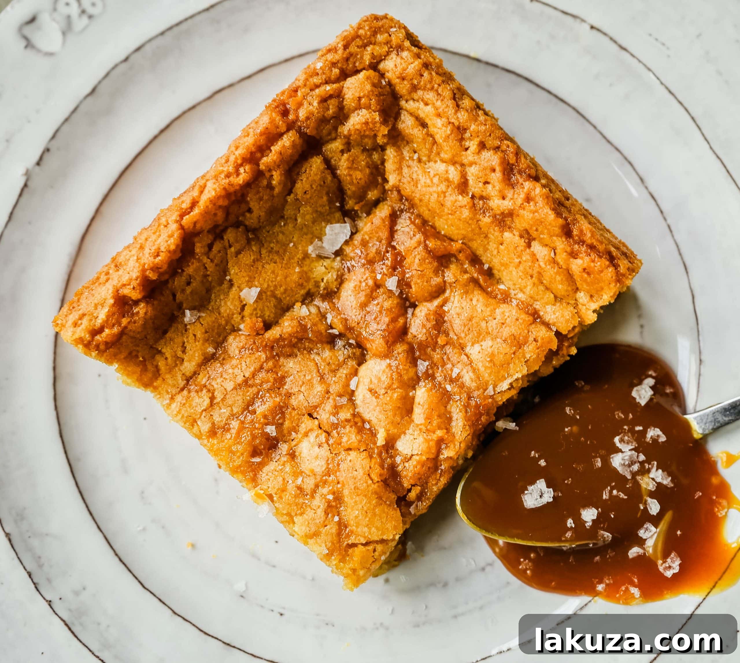 Salted Caramel Blondie Bliss 5 A pan of freshly baked Salted Caramel Blondies, still warm, with visible swirls of caramel and golden brown edges.