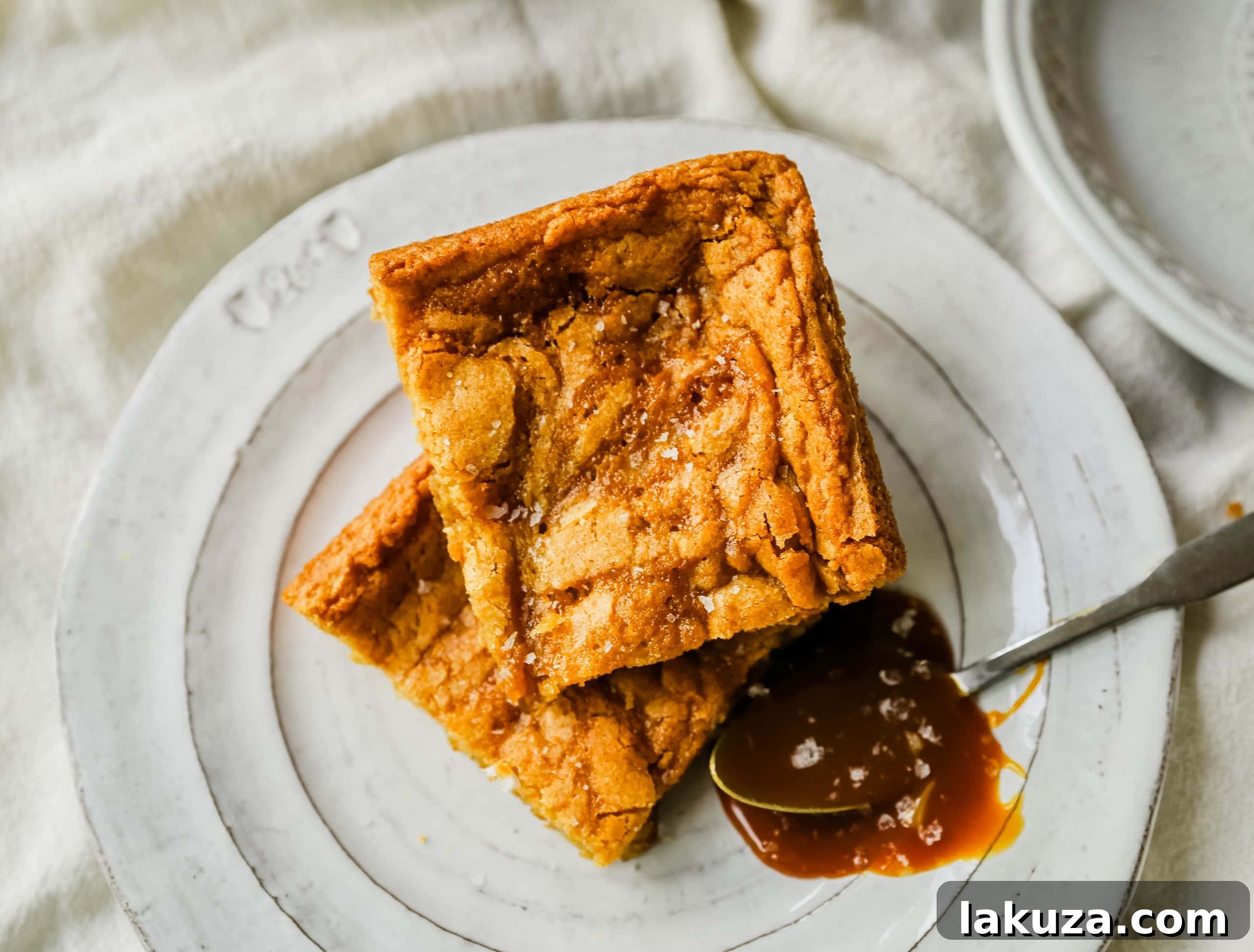 Salted Caramel Blondie Bliss 6 A single piece of Salted Caramel Blondie, showing its thick, chewy texture and rich caramel swirls, ready to be enjoyed.
