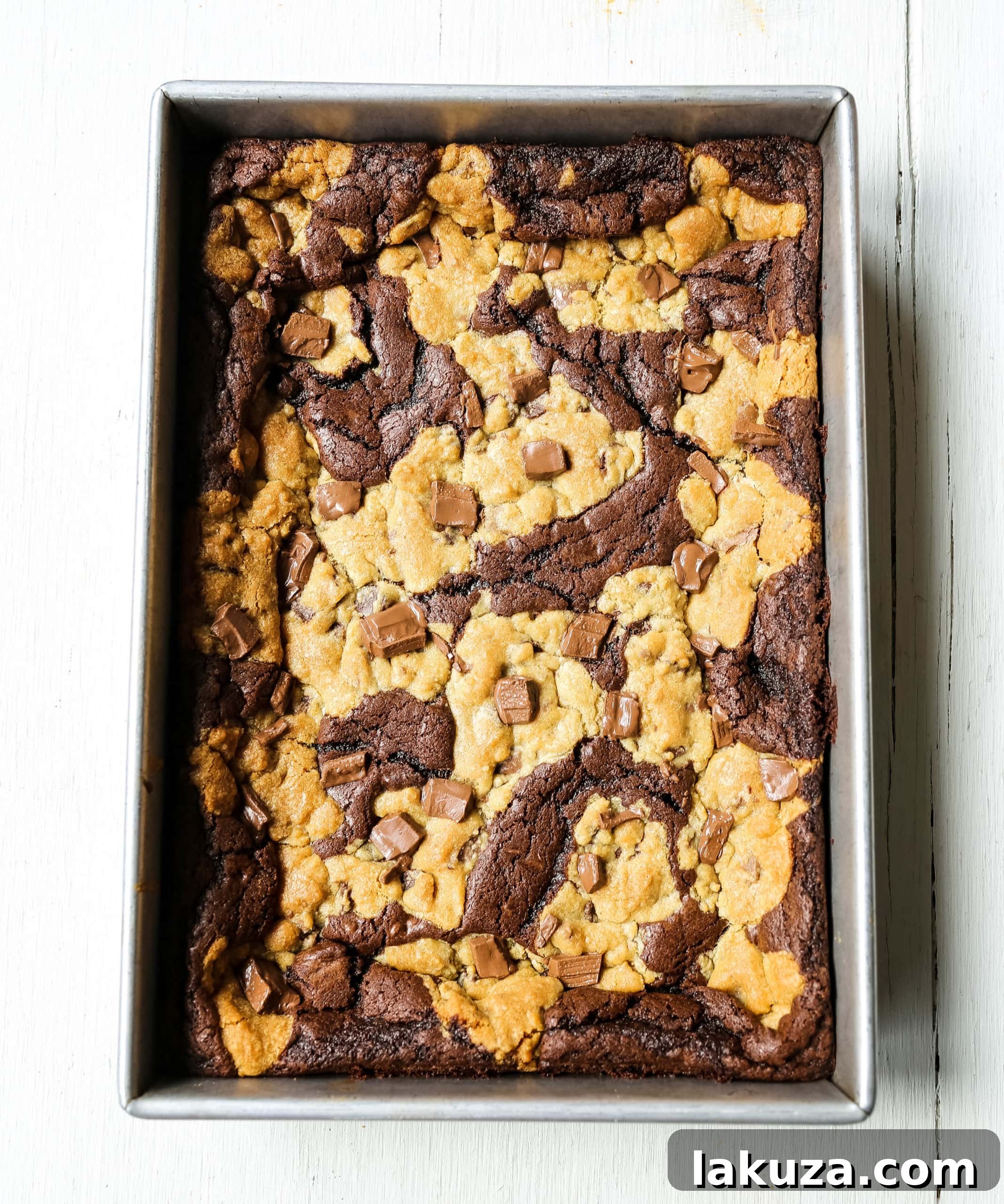 Close-up of freshly baked Brookies, showing the distinct layers of chocolate chip cookie and fudgy brownie, topped with melted chocolate chunks.