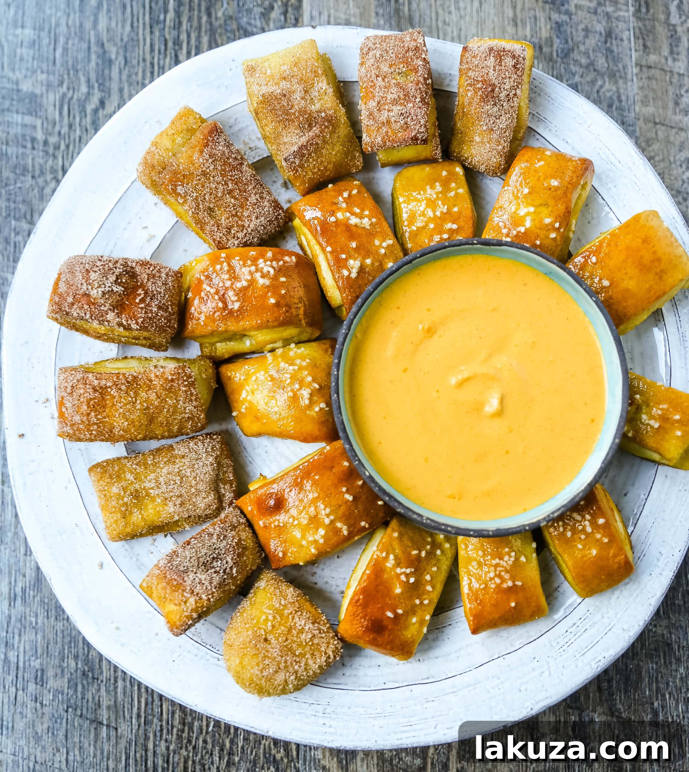 A close-up showcasing a pile of homemade pretzel bites, some with coarse salt, others plain, on a light background.