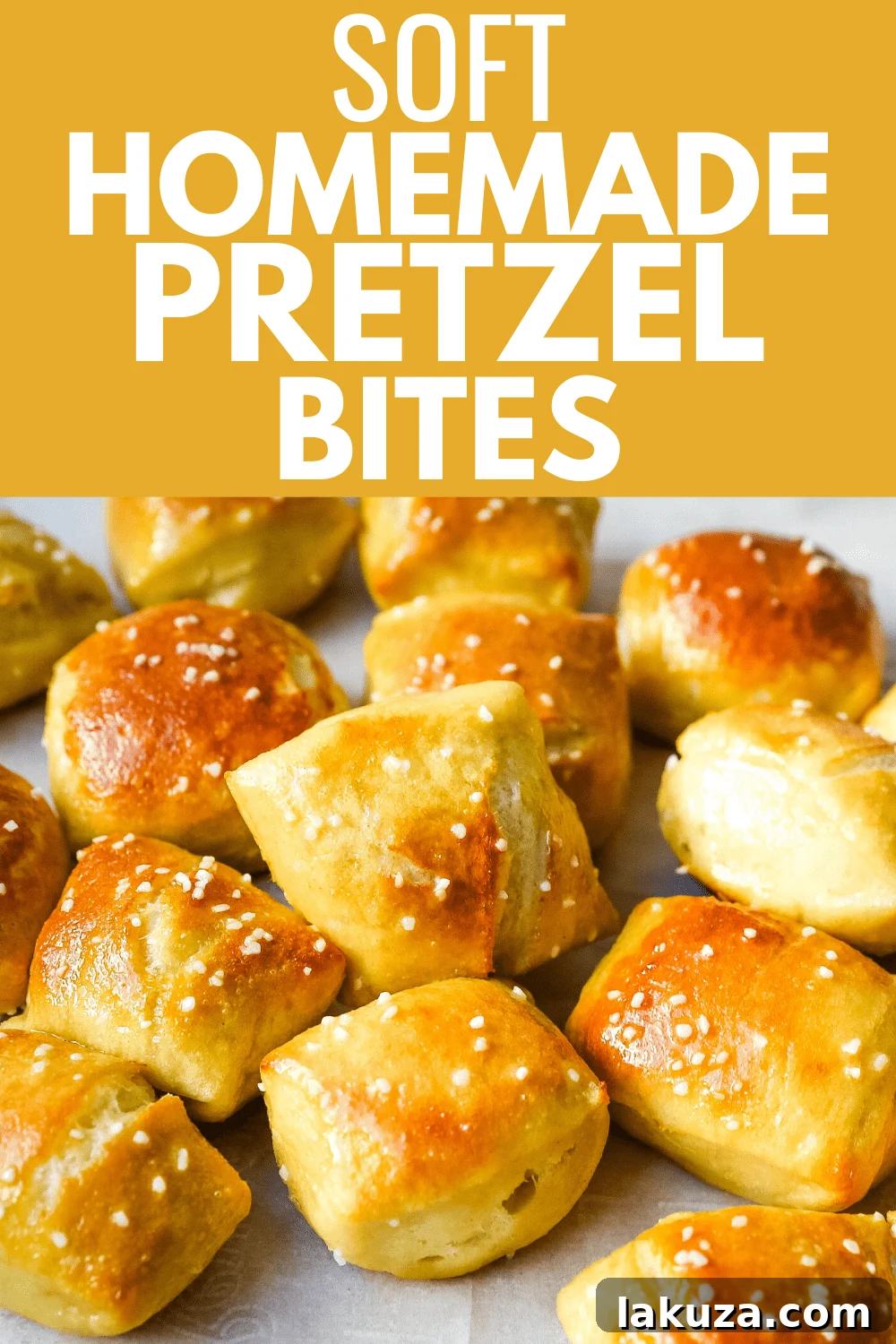 A close-up of a hand reaching for a freshly baked, salted homemade pretzel bite, emphasizing its irresistible appeal.