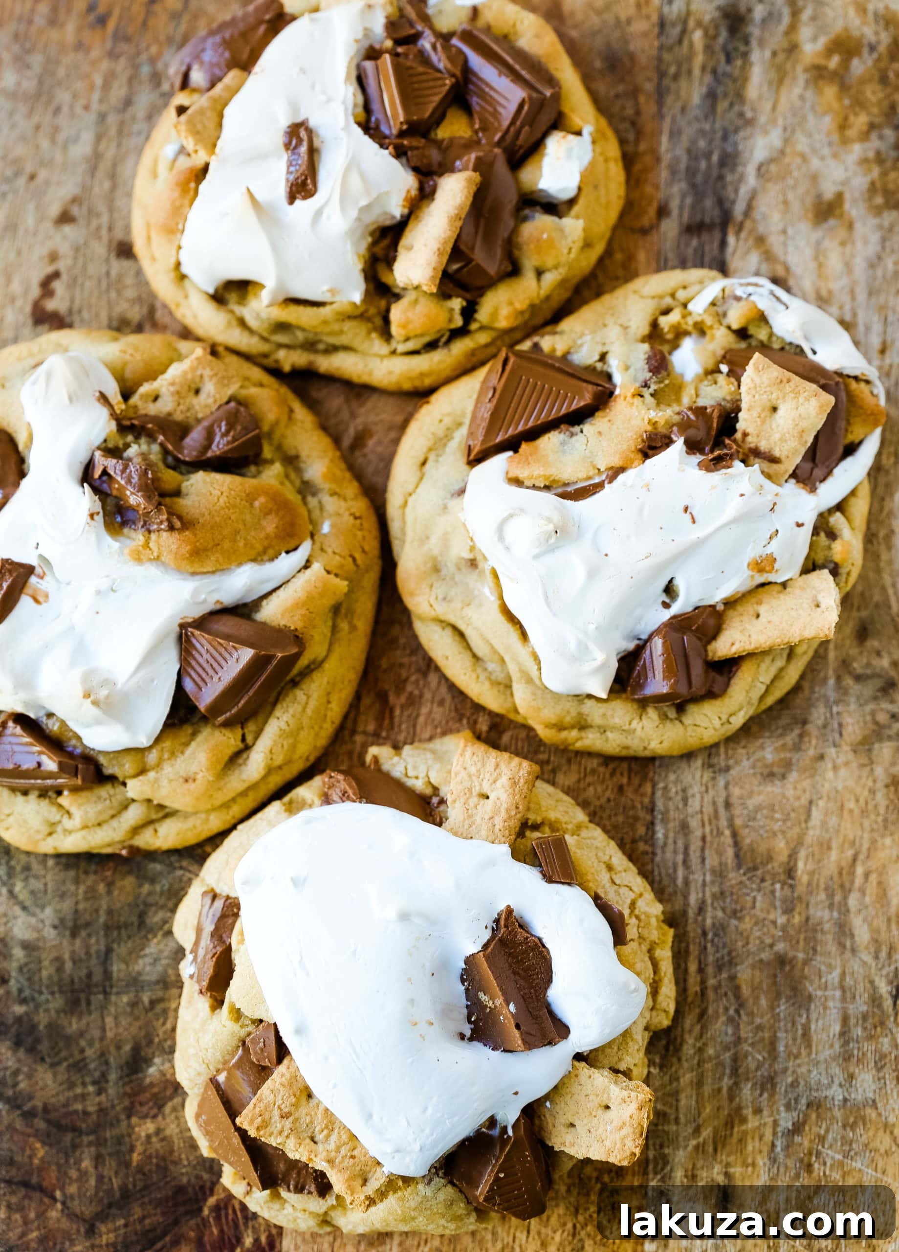 Stack of freshly baked Chocolate Chip S'mores Cookies on parchment paper, highlighting the gooey marshmallow and chocolate.