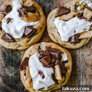 Chocolate Chip S'mores Cookies Warm milk chocolate chip cookies with creamy marshmallow fluff and graham cracker. The most perfect s'mores and chocolate chip cookie in one! www.modernhoney.com #cookies #smores #smorescookies #chocolatechipcookies