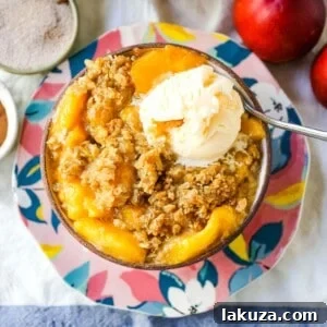 Peach Crisp: Fresh sweetened peaches with a brown sugar oat crumble topping with creamy vanilla ice cream. The perfect summer dessert!