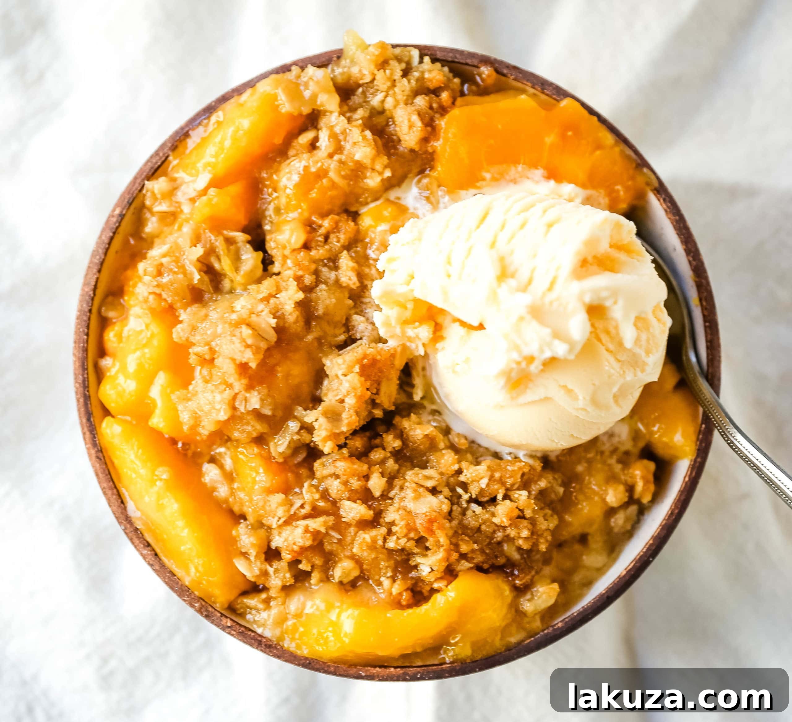 Golden Peach Delight 4 Close-up of a bubbling Peach Crisp in a baking dish, showing the juicy peaches and golden oat crumble.