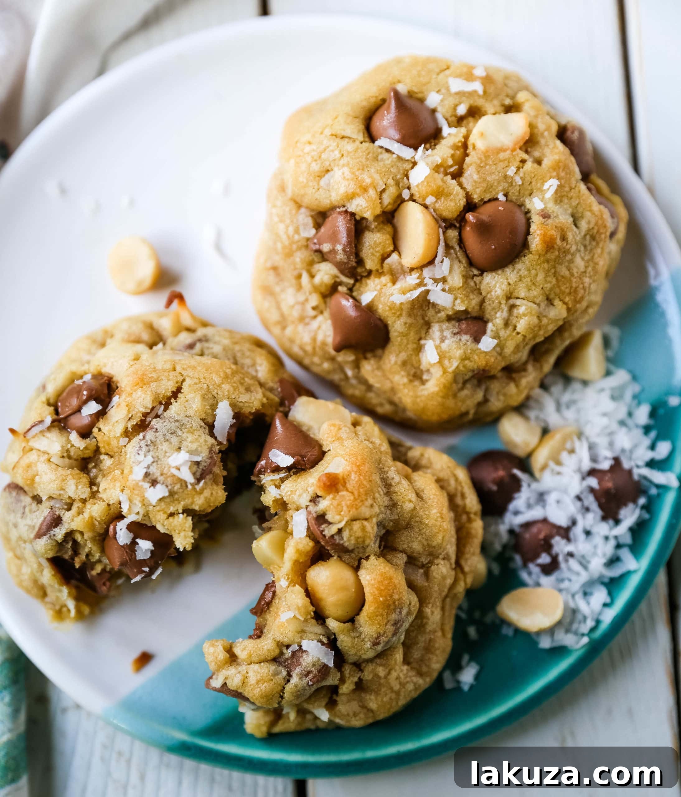 Irresistible Milk Chocolate Macadamia Coconut Cookies 6 A hand reaching for a warm, freshly baked Milk Chocolate Chip Macadamia Nut Coconut Cookie from a cooling rack.