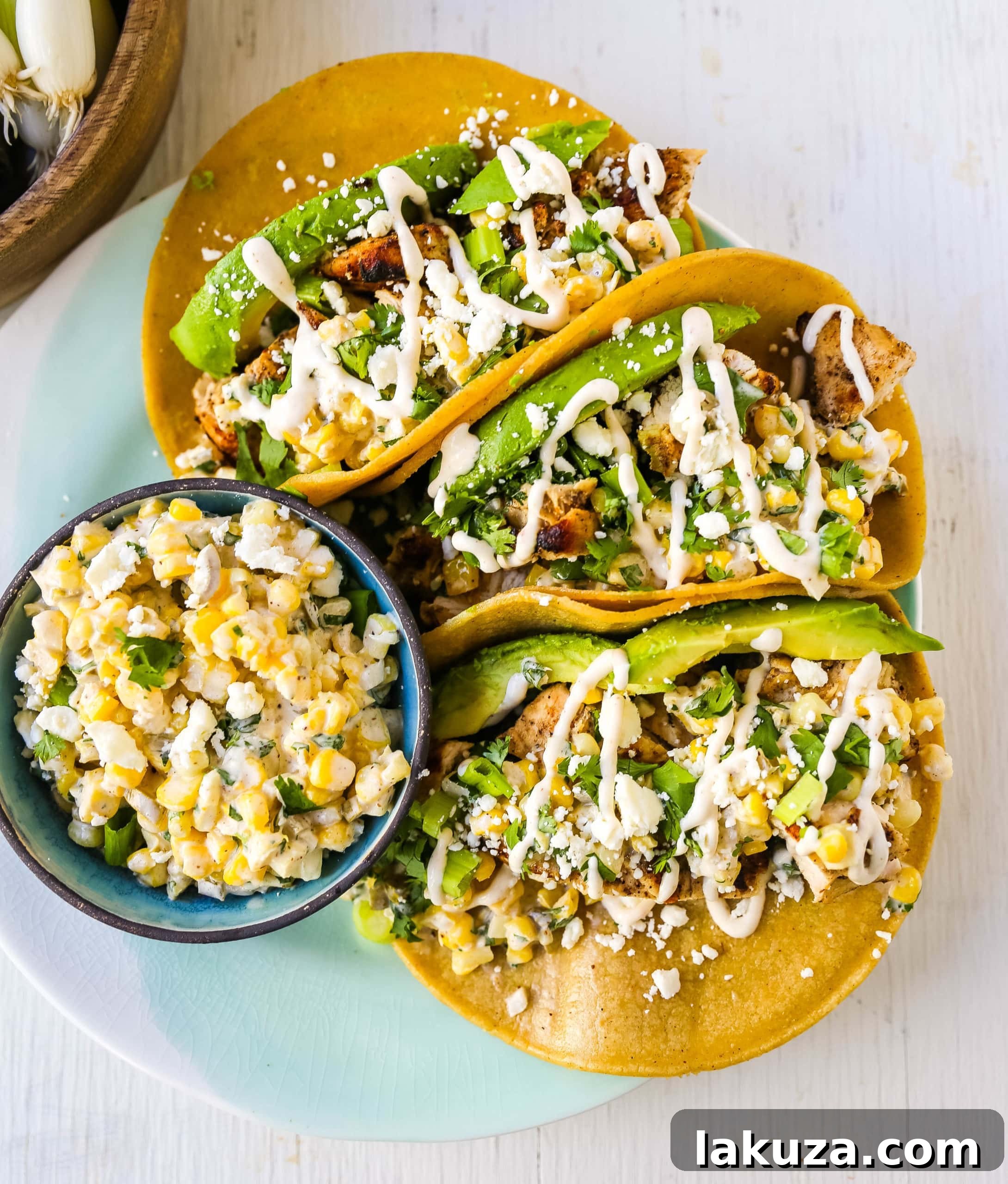Delicious Mexican Street Corn Chicken Tacos with fresh avocado and cotija cheese