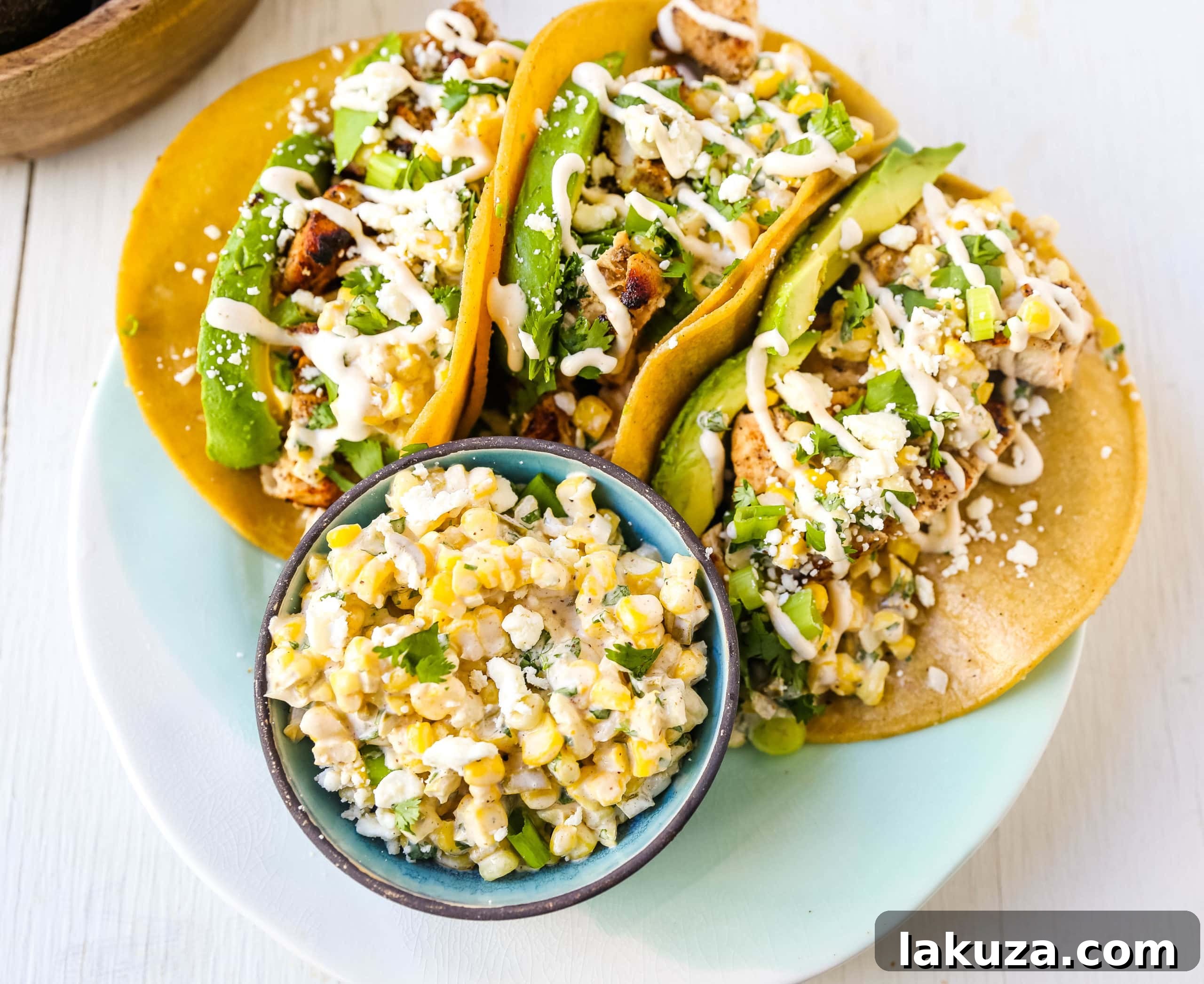 A beautifully plated Mexican Street Corn Chicken Taco drizzled with spiced crema