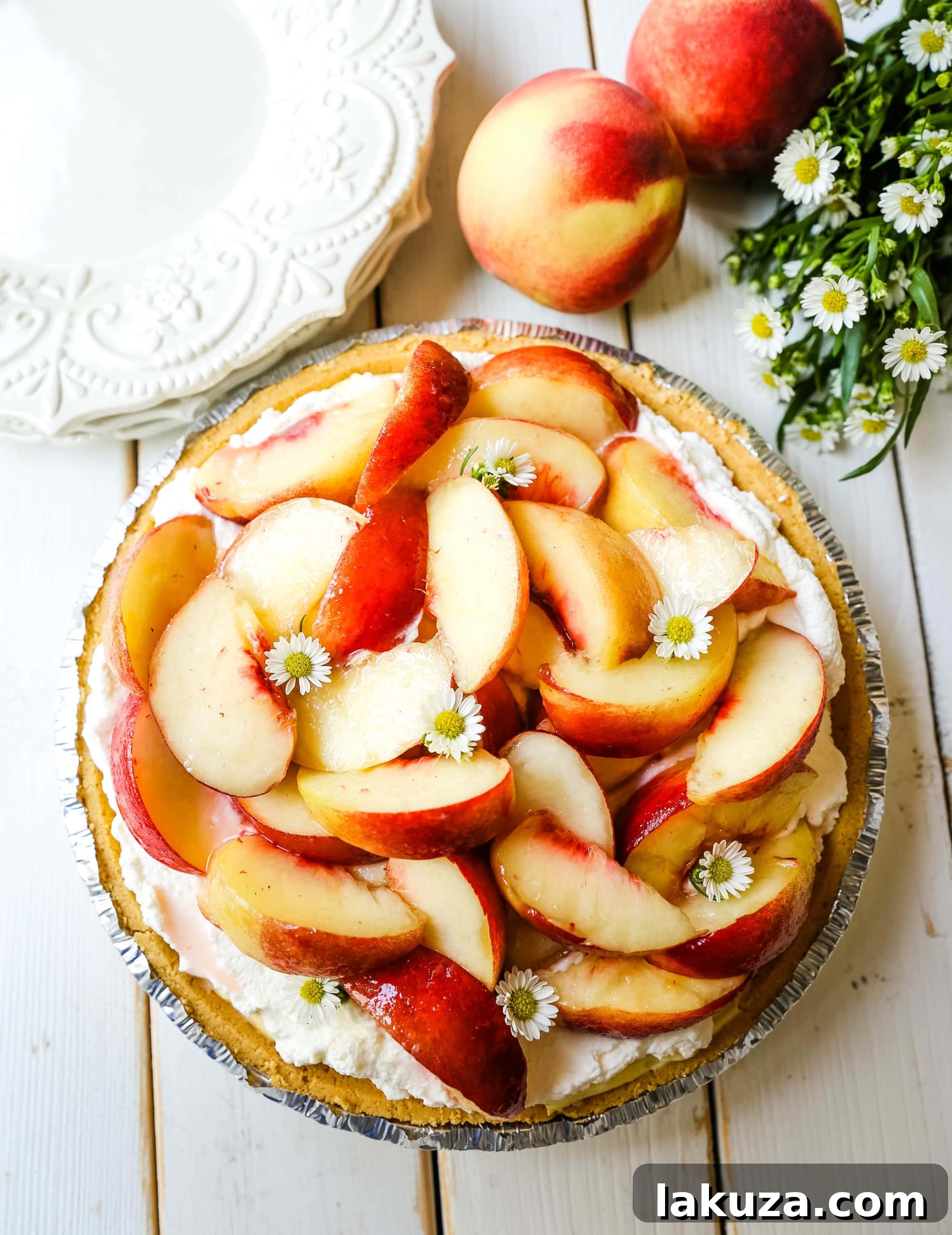An aerial shot of the finished Peaches and Cream Pie, showcasing its beautiful arrangement of peaches and whipped cream.