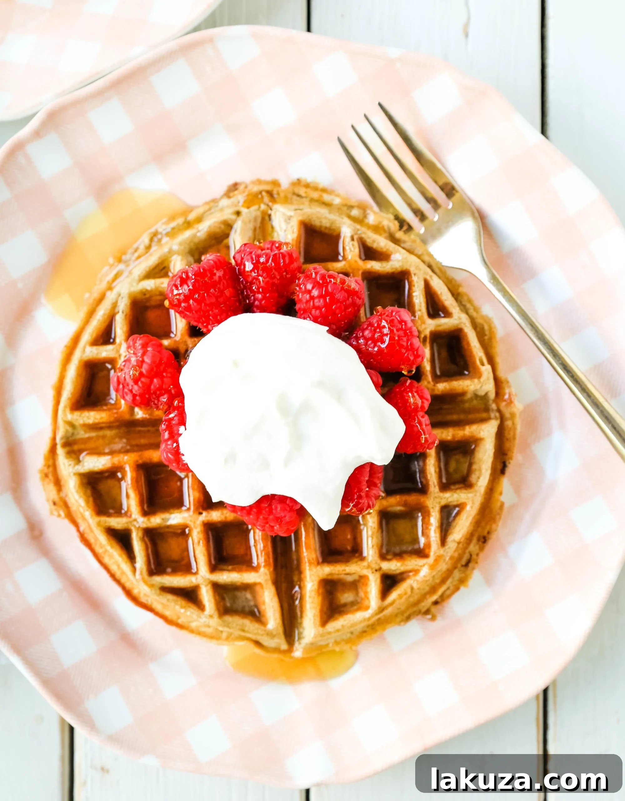 Close-up of golden brown gluten-free banana oat waffles with a drizzle of maple syrup