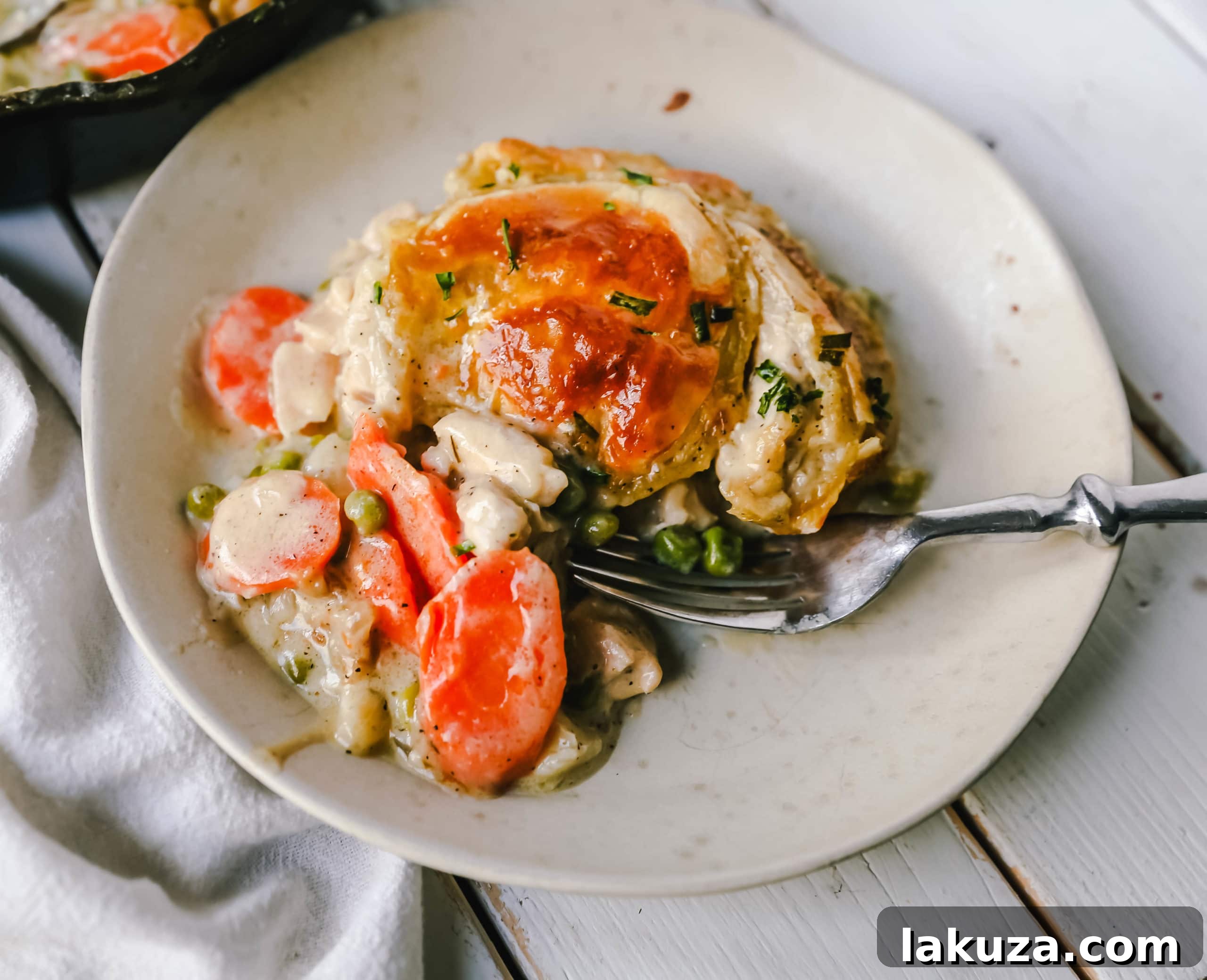 Golden, flaky puff pastry topping a bubbling Skillet Chicken Pot Pie, fresh from the oven. The perfect comfort food, ready to be served from the cast iron skillet.