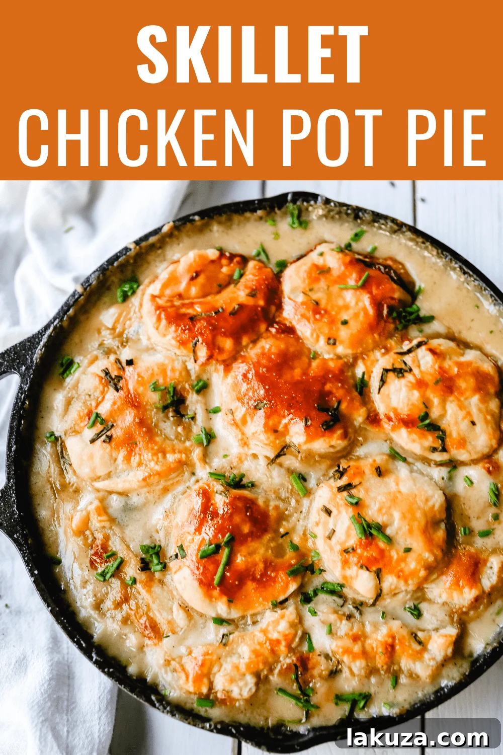 A delicious Skillet Chicken Pot Pie, perfectly baked with a golden, flaky puff pastry crust, displayed on a wooden surface. An inviting and easy comfort meal.