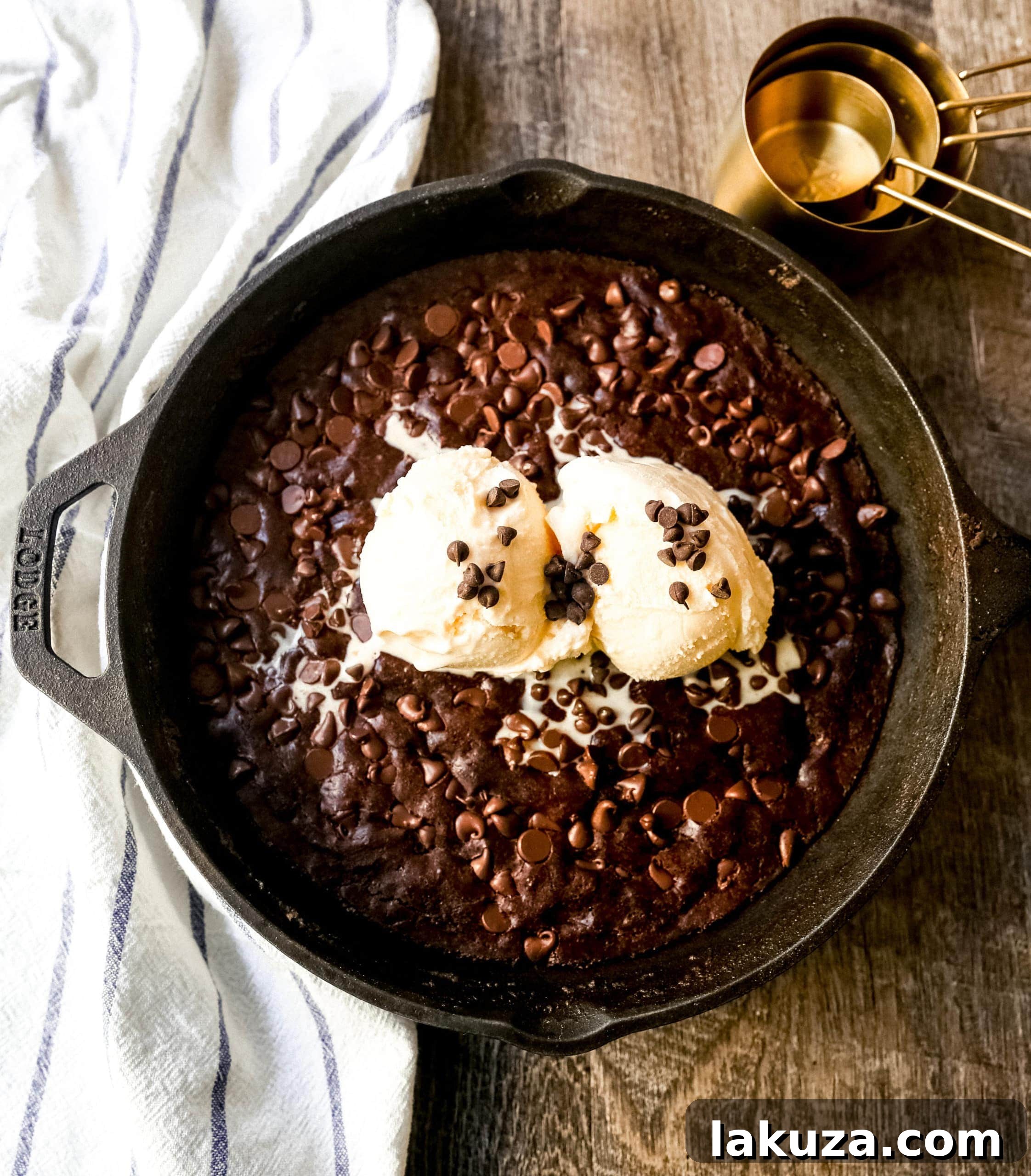 Double Chocolate Chip Skillet Cookie, rich and chewy dessert baked in a cast-iron skillet, topped with vanilla ice cream and hot fudge for ultimate indulgence.