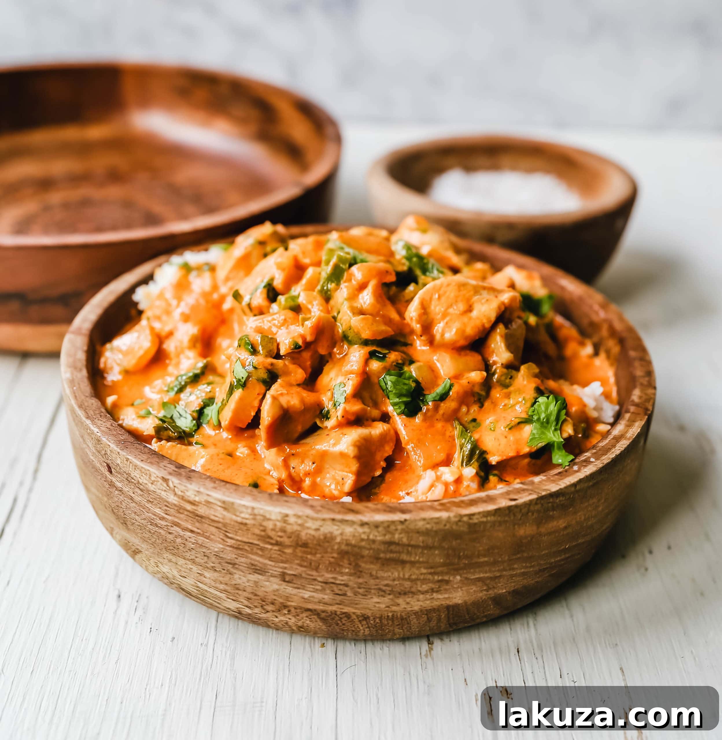Authentic Thai Red Chicken Curry 3 Close-up of succulent chicken pieces simmering in a luscious red curry sauce, infused with aromatic spices and coconut milk.