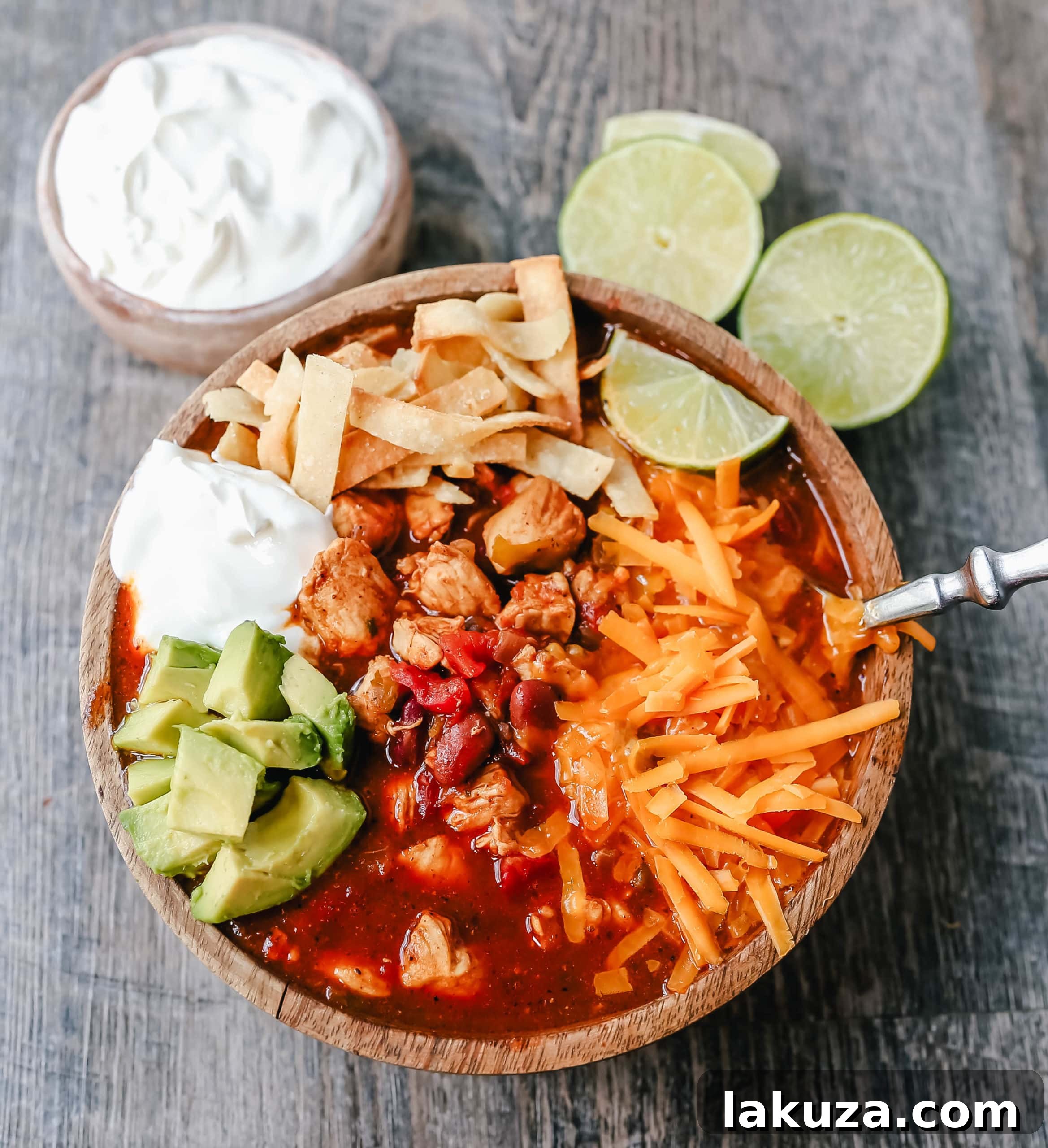 Delicious Chicken Chili in a bowl, featuring succulent chicken, vibrant green chilies, diced tomatoes, and robust chili beans, all infused with aromatic Mexican spices. The secret ingredients make this homemade dish truly stand out. Recipe by Modern Honey. #chickenchili #comfortfood