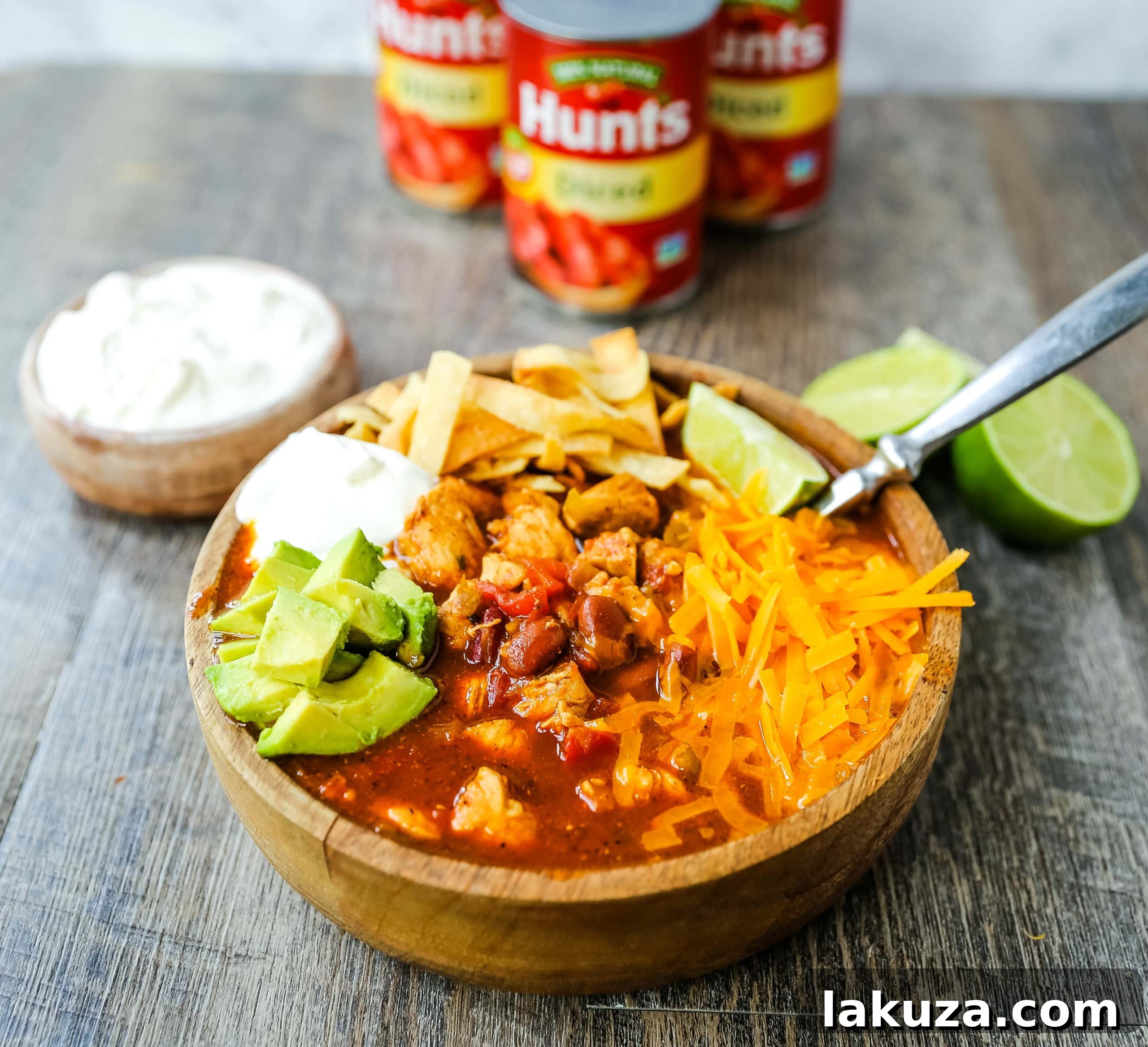 A close-up shot of homemade chicken chili in a pot, simmering to perfection. Rich with Mexican spices, tender chicken, green chilies, tomatoes, and hearty beans, this chili boasts secret ingredients for an extraordinary flavor. Ready to be served! #chickenchili #recipeideas