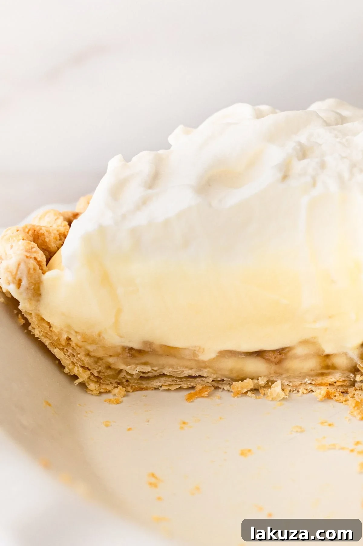 A perfect slice of easy homemade banana cream pie, ready to be enjoyed, highlighting its creamy layers and fresh banana.