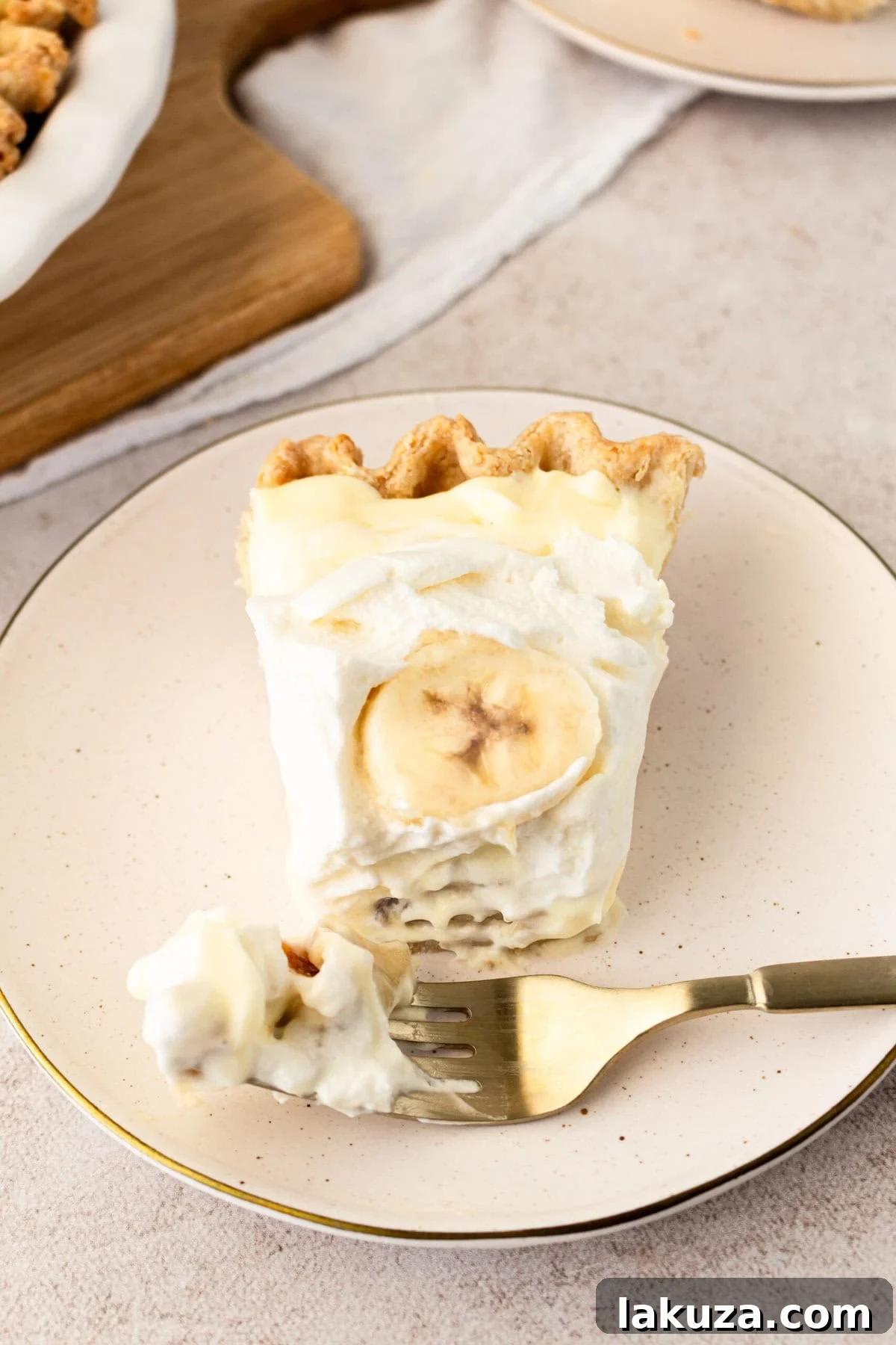 A person taking a delightful bite out of a freshly made, creamy homemade banana cream pie, showcasing its appealing texture and taste.