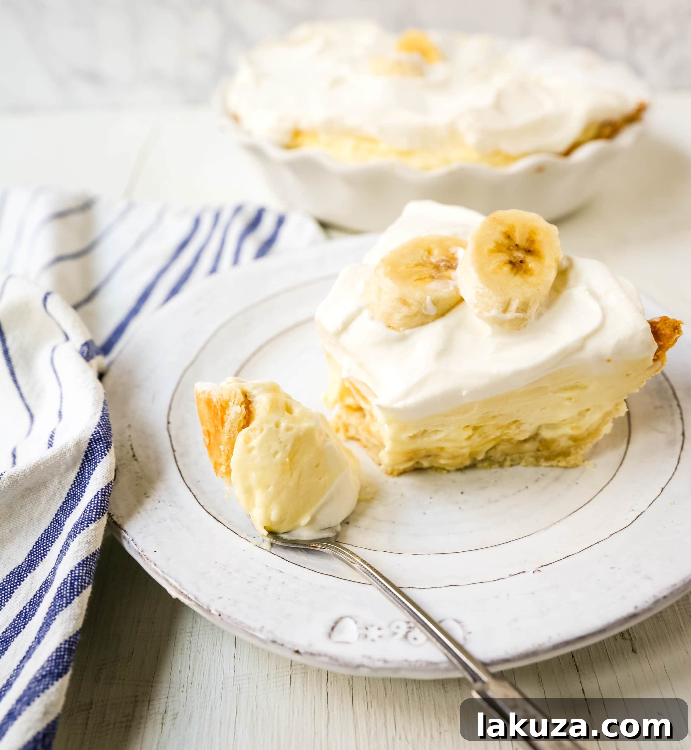 A close-up shot of a banana cream pie, highlighting its creamy layers and fresh fruit, ready to be served.