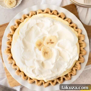 A slice of classic banana cream pie with a crisp crust, creamy filling, and fluffy whipped topping.