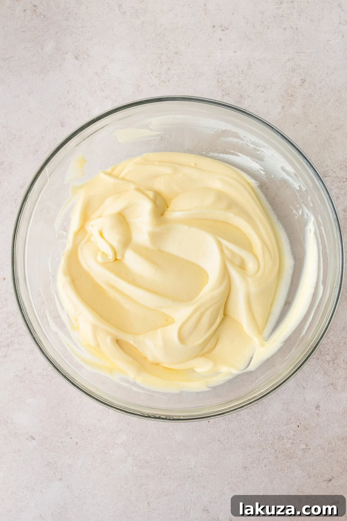 The combined vanilla pudding, sweetened condensed milk, cold water, and whipped cream mixture, creating a smooth and creamy banana cream pie filling.