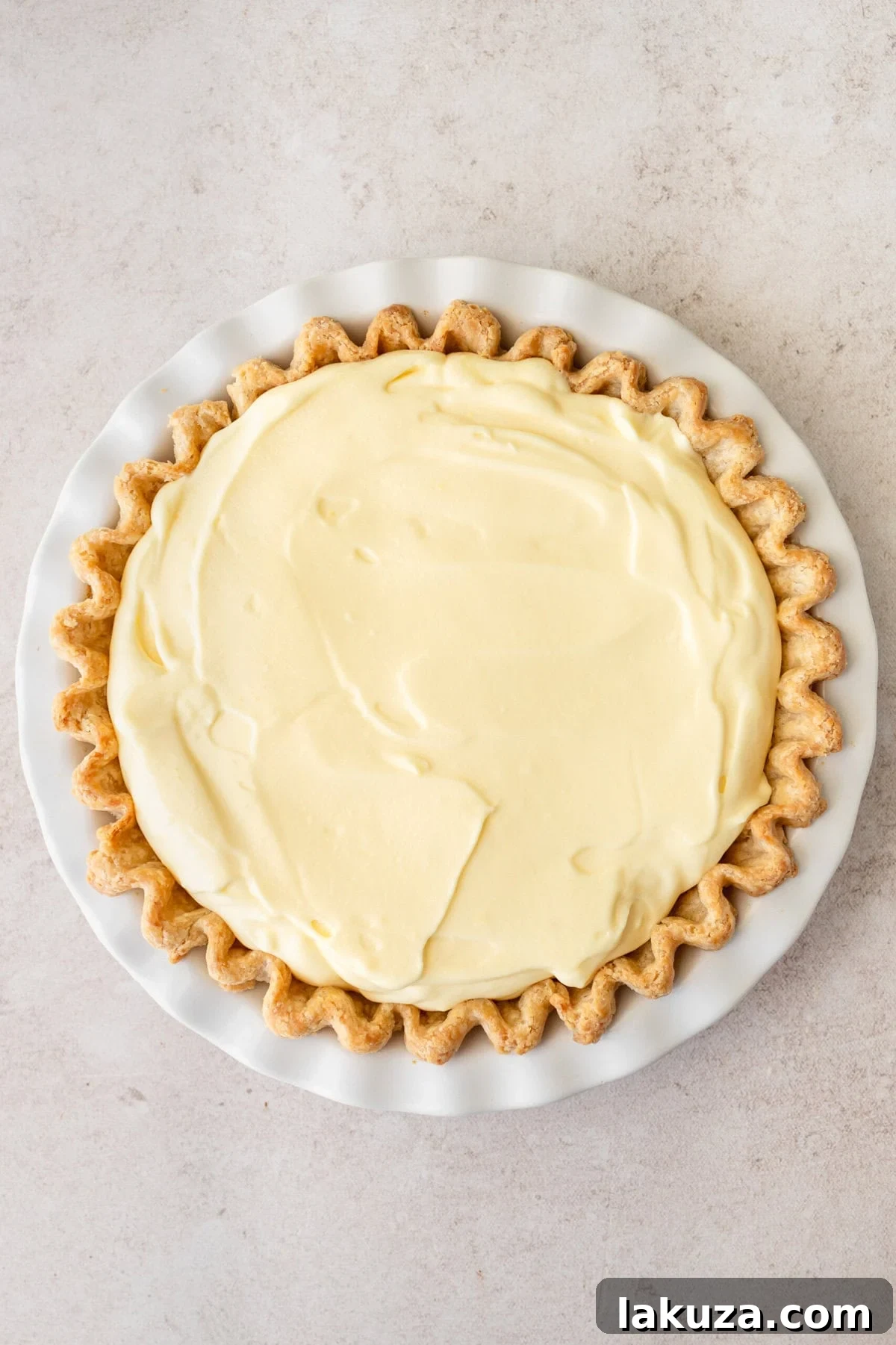 A generous layer of creamy vanilla pudding filling, enriched with whipped cream, spread over fresh bananas in the pie crust.
