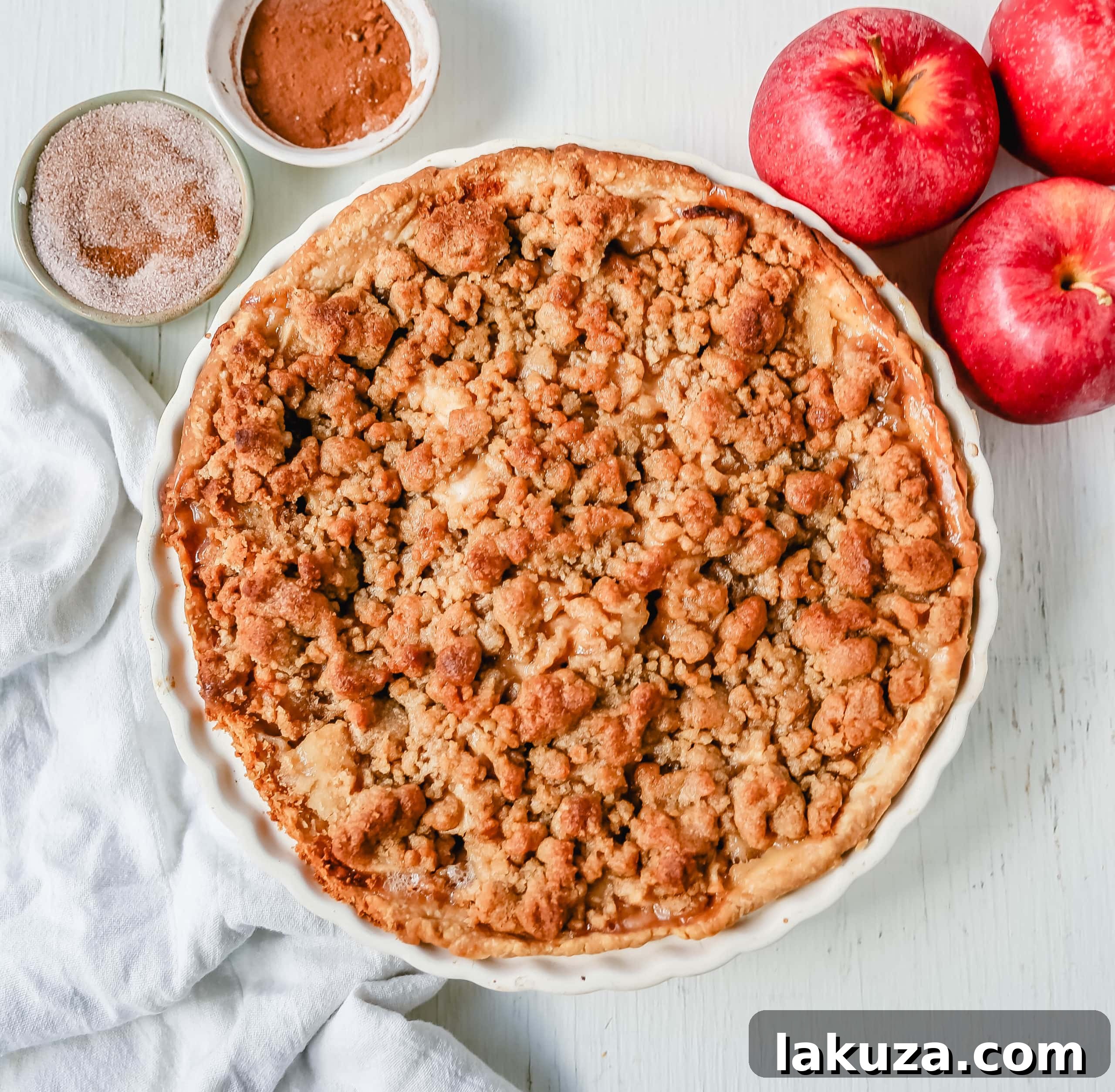 Authentic Dutch Apple Crumble 3 Close-up of a freshly baked Dutch apple pie, showcasing its golden, crumbly streusel topping and bubbling apple filling.