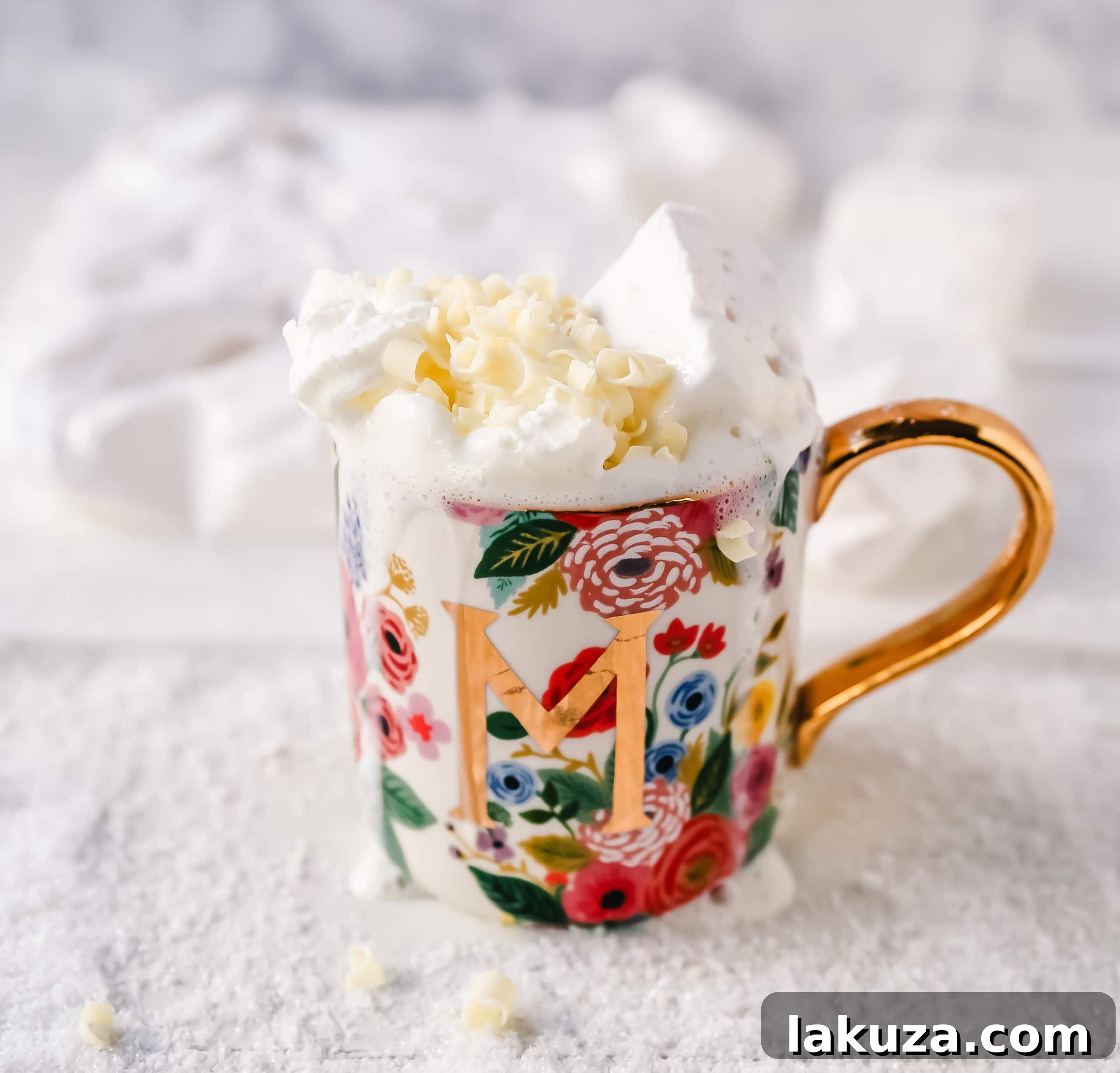 Close-up of creamy white hot chocolate with a frothy top, hinting at its rich texture, garnished with white chocolate shavings.