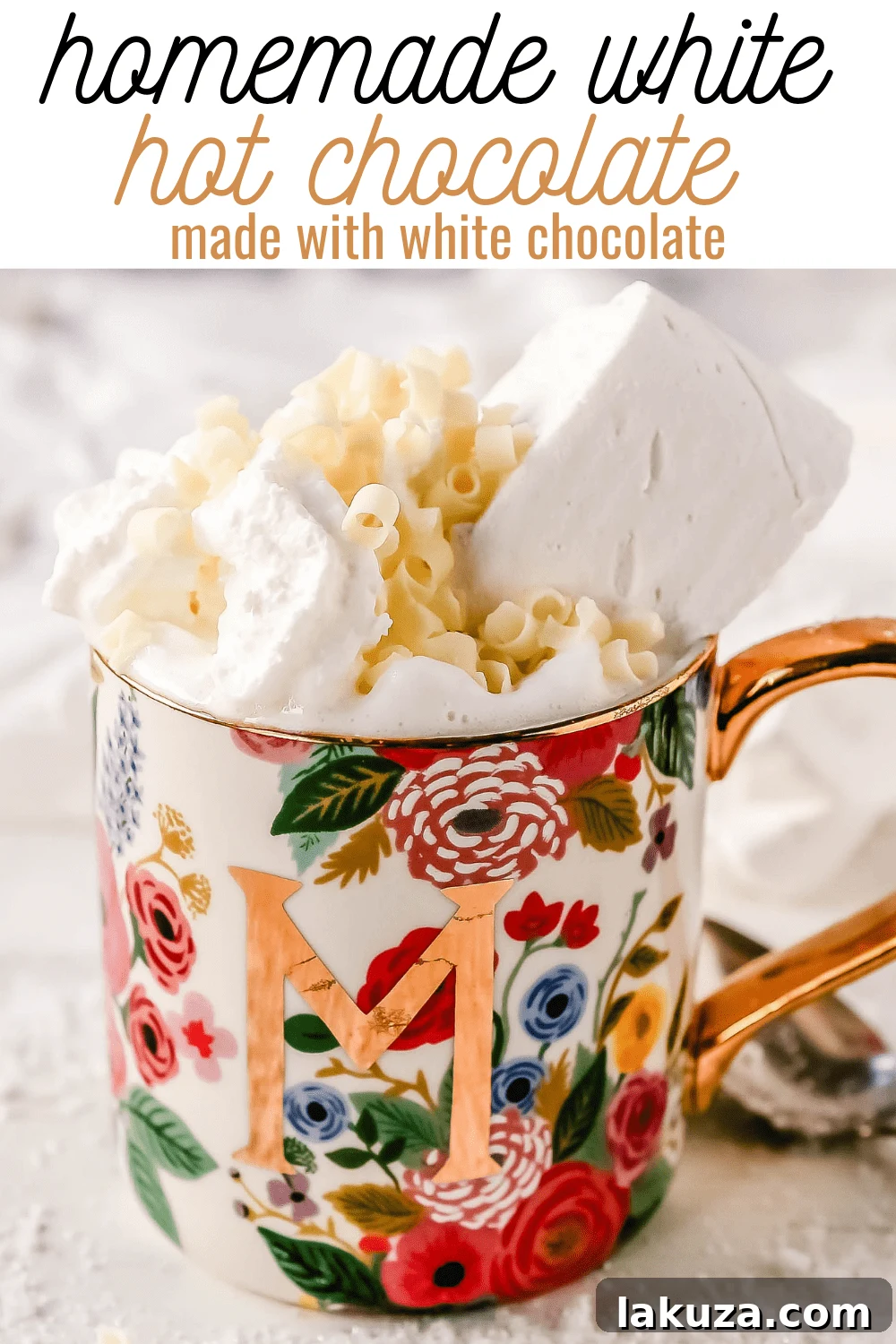 A festive arrangement featuring two mugs of white hot chocolate, adorned with whipped cream and sprinkles, alongside cozy holiday decorations.