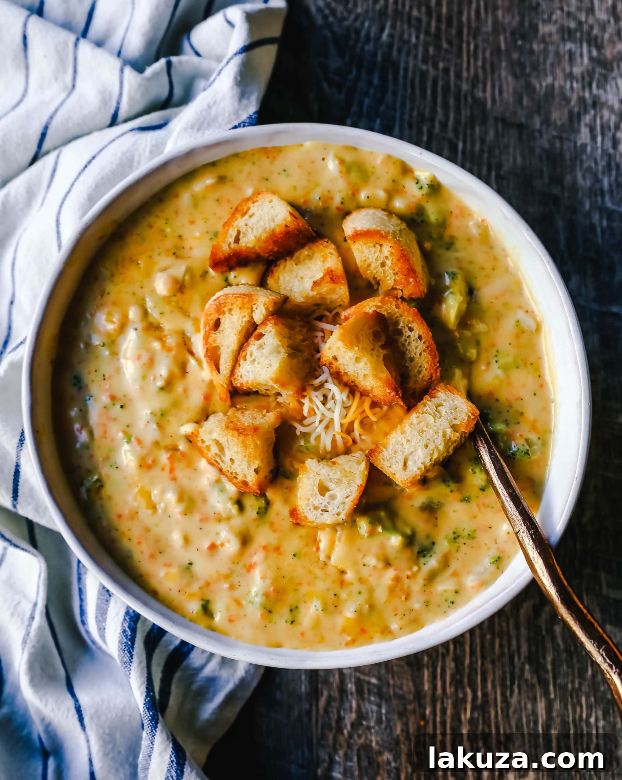 Sharp Cheddar Broccoli Comfort 5 Serving of homemade Broccoli Cheddar Soup, garnished with a sprinkle of fresh chives and served alongside a slice of crusty bread, ready to be enjoyed.