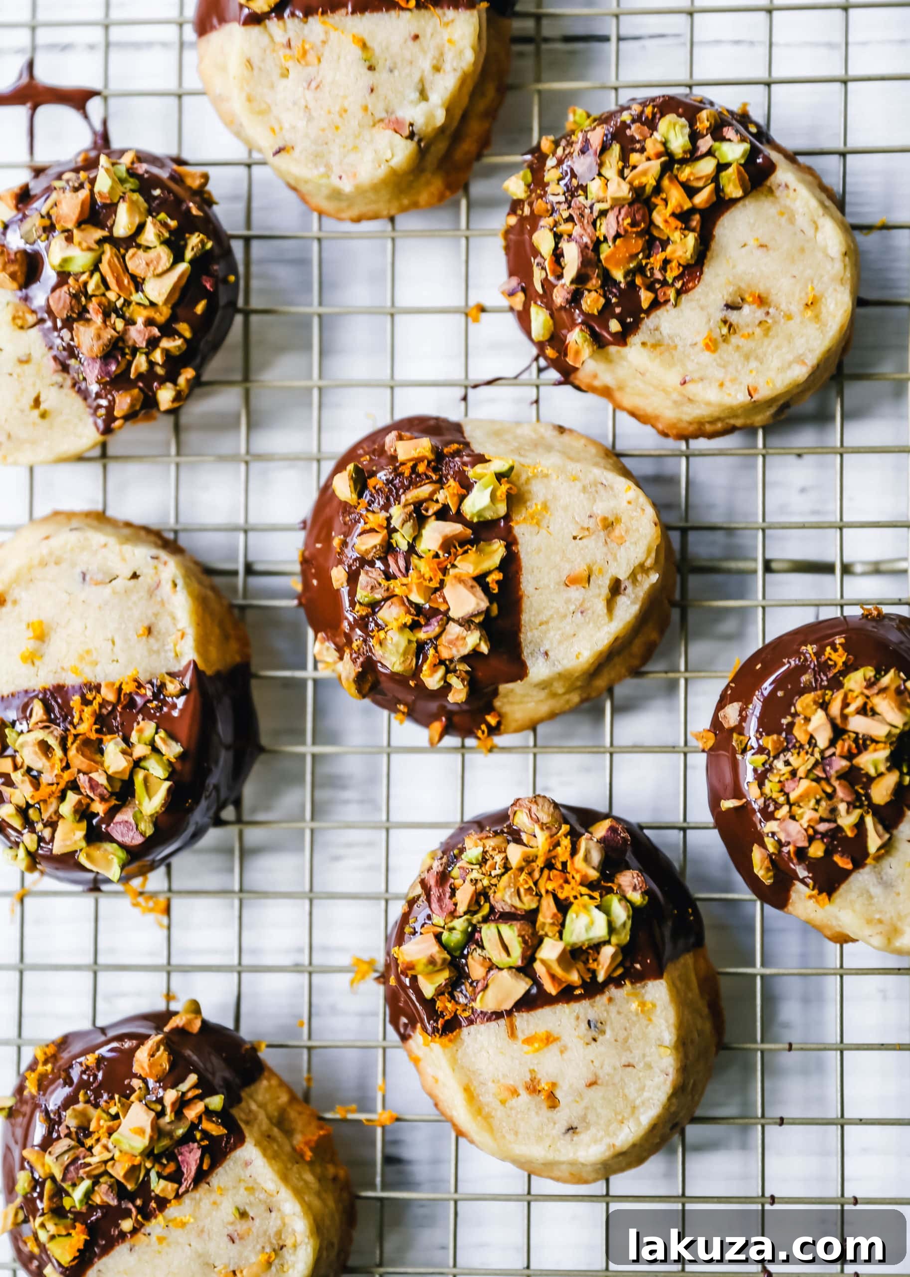 Gourmet Chocolate Dipped Pistachio Shortbread 4 A beautifully arranged platter of festive shortbread cookies, some dipped in chocolate and garnished with pistachios and orange zest.