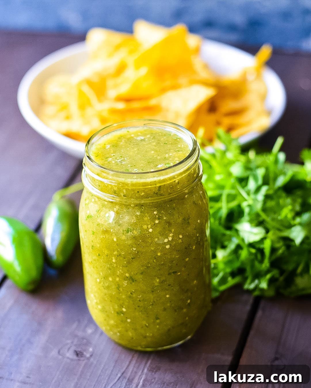 Sweet Emerald Salsa 4 Simple ingredients for Sweet Salsa Verde laid out on a cutting board, including canned tomatillos, cilantro, and jalapenos
