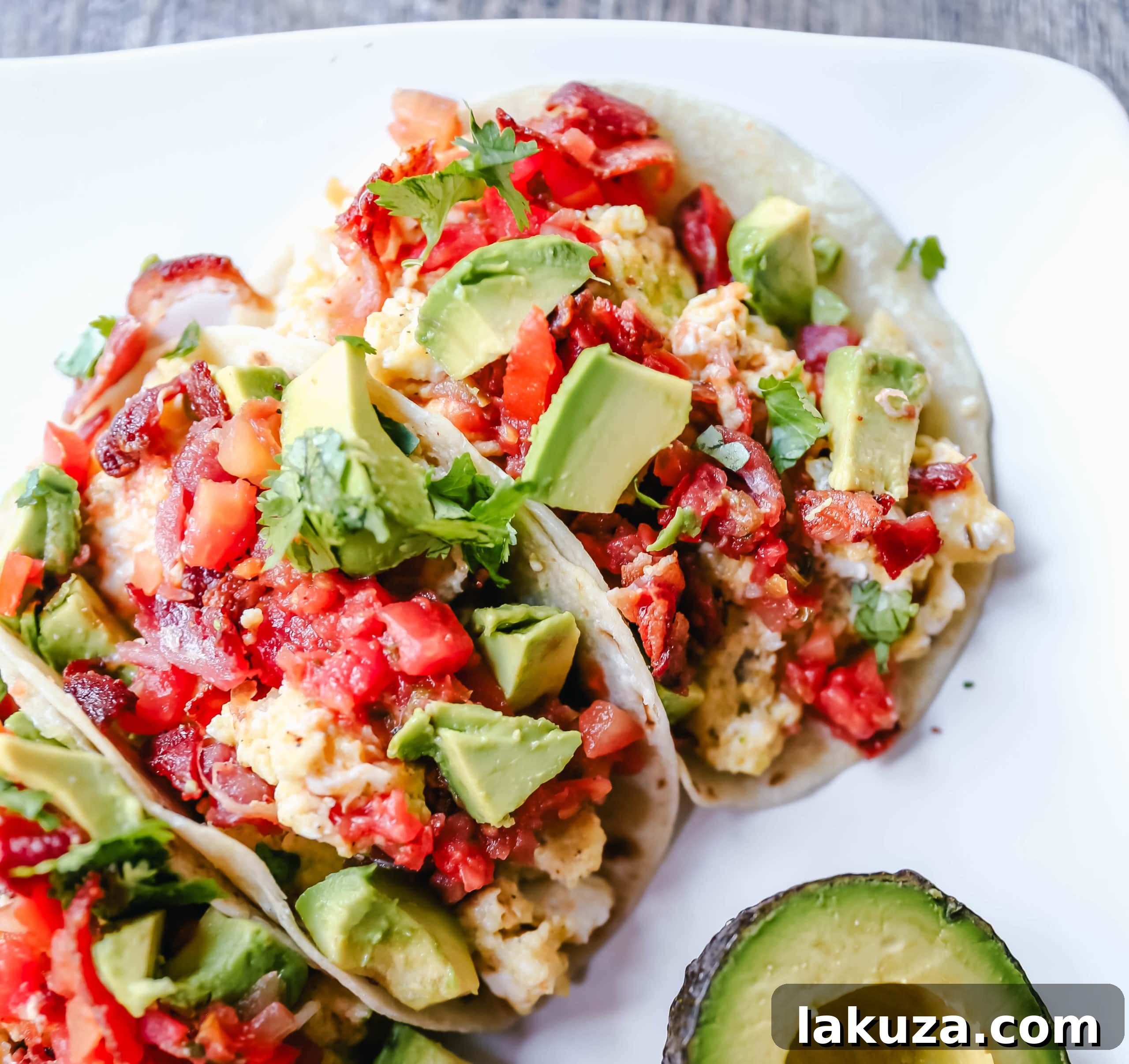 A plate of two vibrant breakfast tacos, ready to be enjoyed.