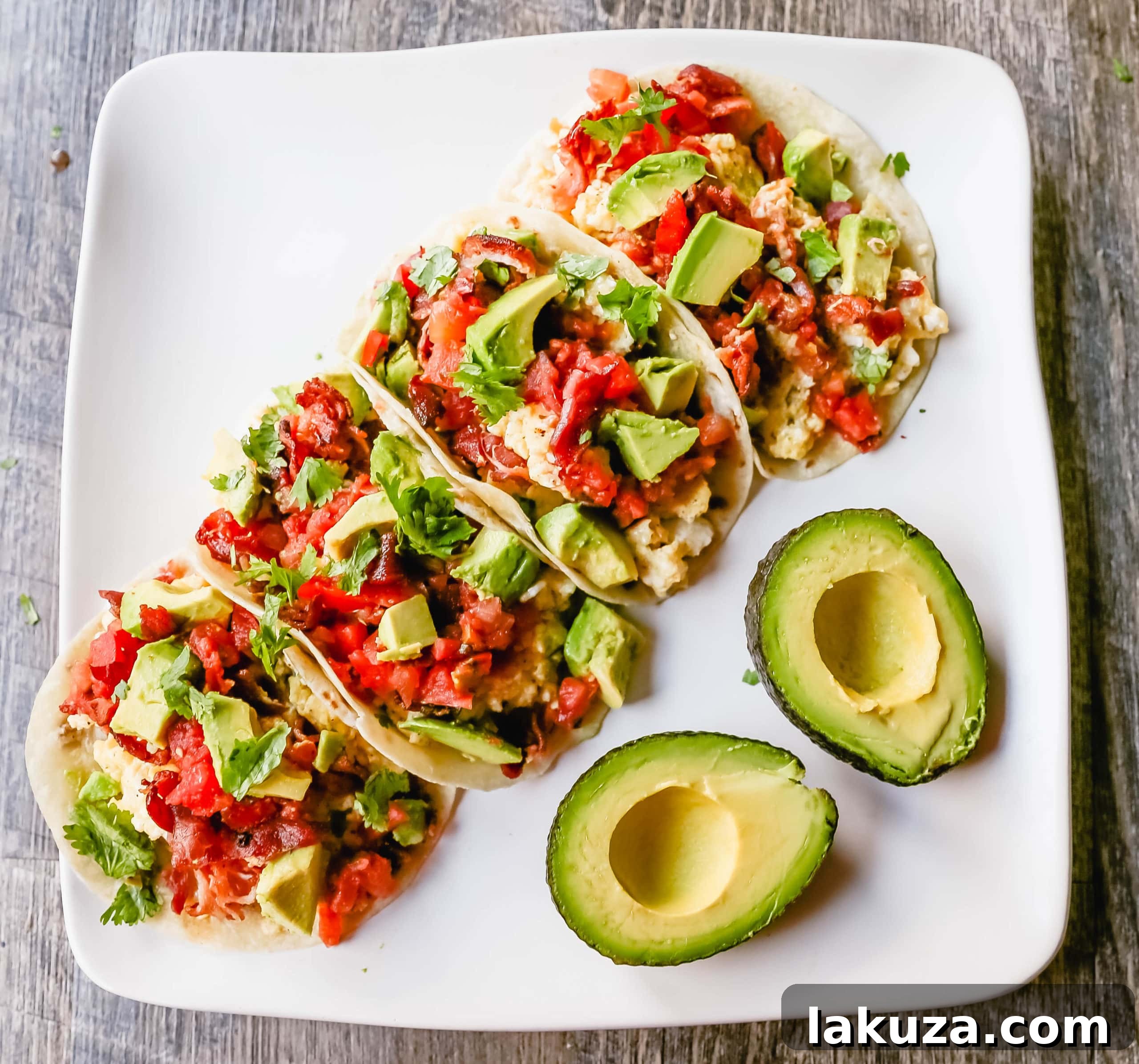 Ingredients for breakfast tacos laid out on a wooden board.