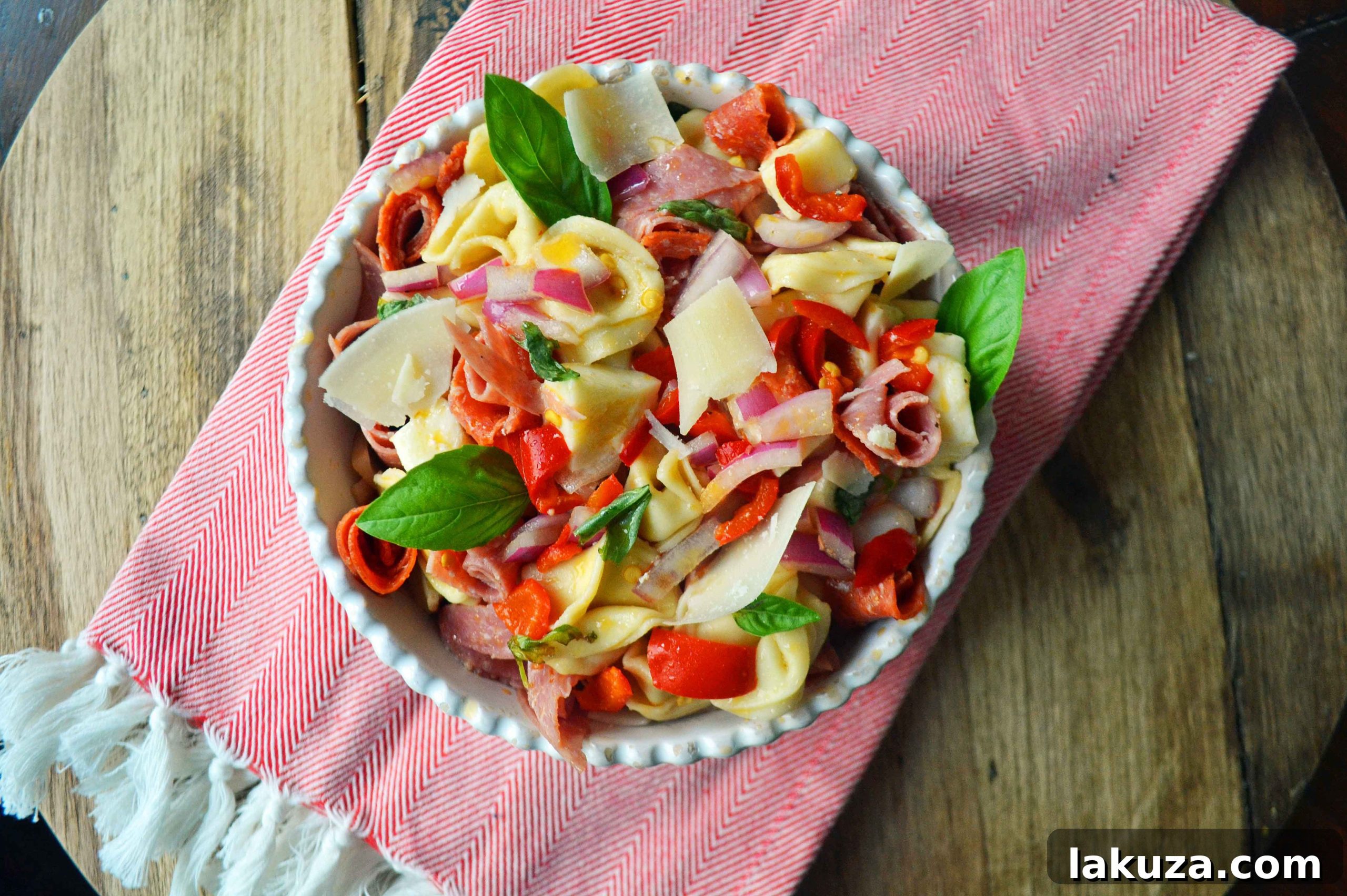 Close-up view of Antipasto Tortellini Pasta Salad with fresh basil garnish