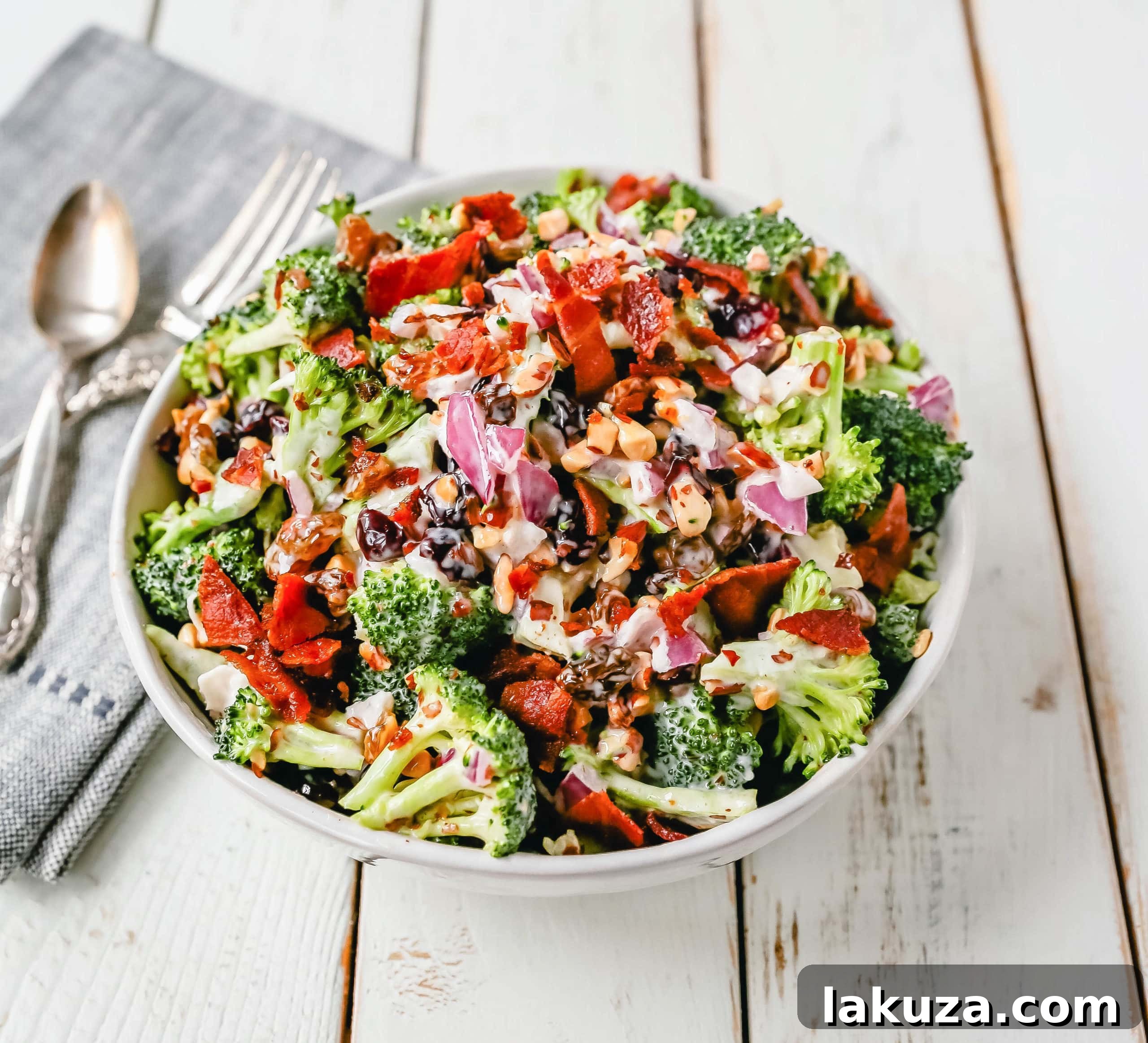 Broccoli Salad. Crunchy broccoli salad with crispy bacon, sweet dried cranberries, onion, nuts, tossed in a sweet and tangy dressing. A classic potluck side dish recipe! www.modernhoney.com #broccolisalad #sidedish #potluck #sides
