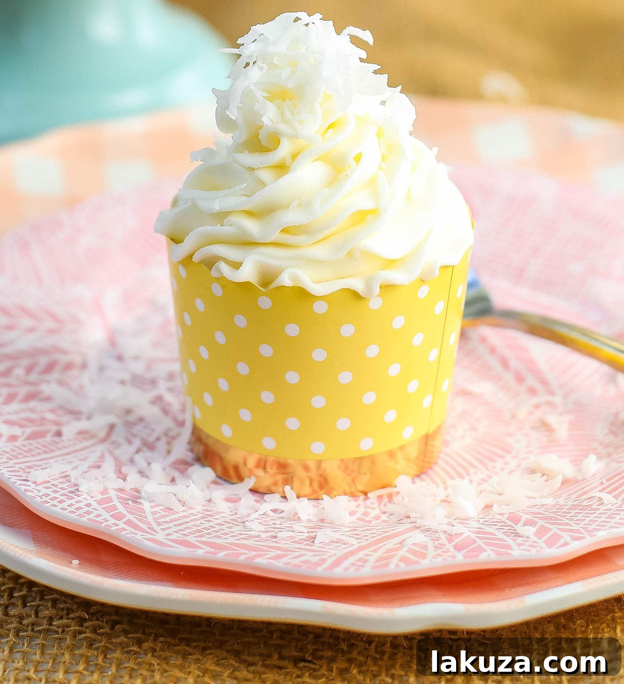 Close-up of a beautifully frosted coconut cupcake, ready to be enjoyed.