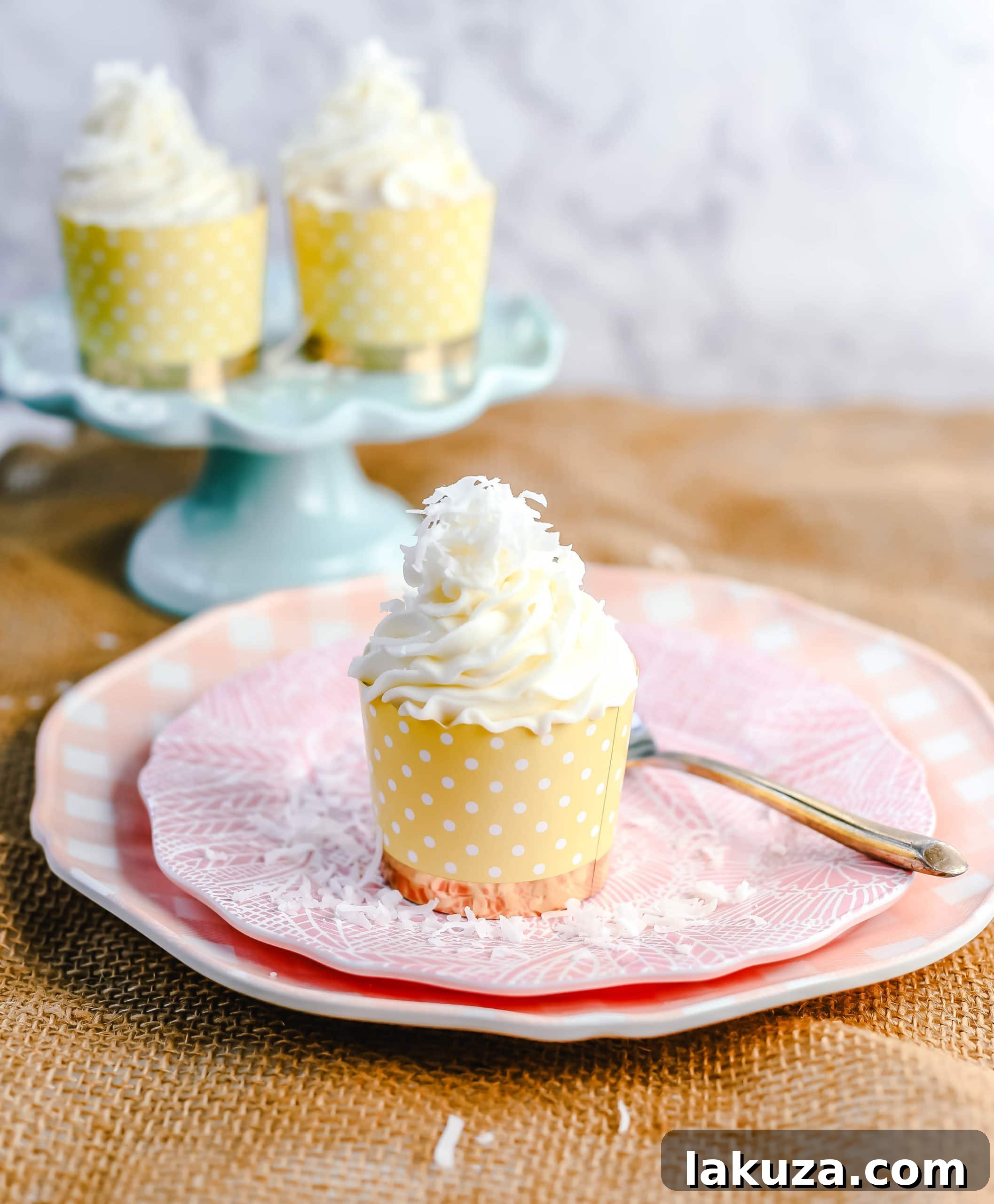 A trio of perfectly baked coconut cupcakes adorned with frosting and shredded coconut.