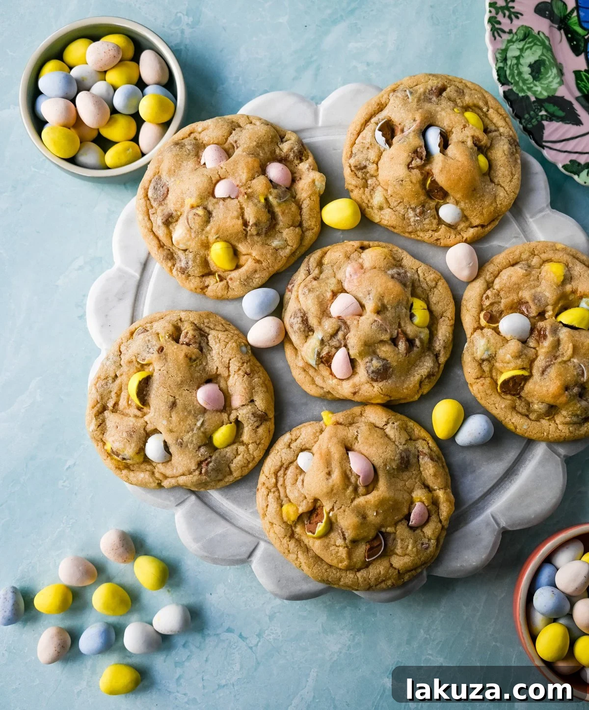 A stack of freshly baked Cadbury Egg Cookies, featuring colorful mini Cadbury eggs and chocolate chips.