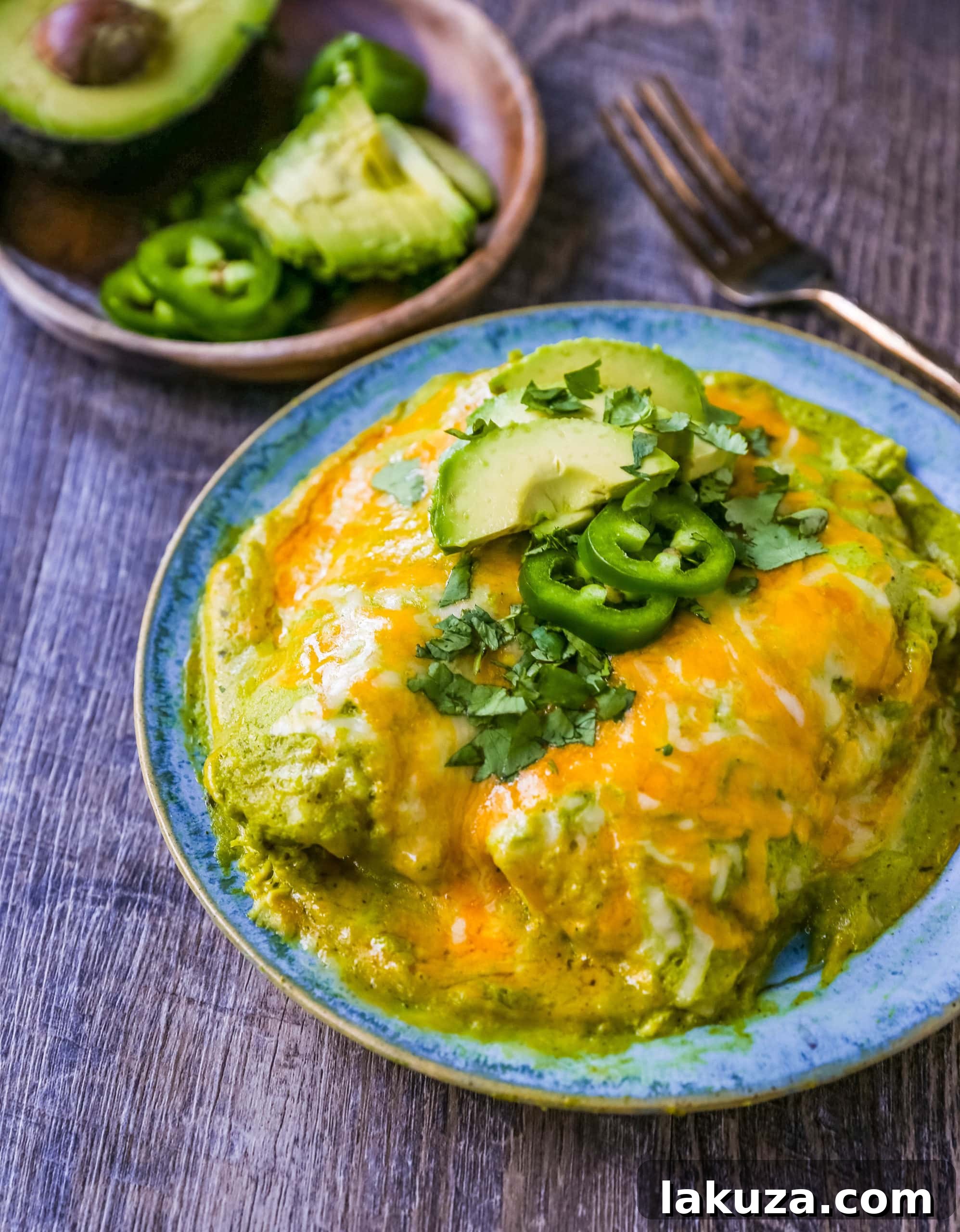Golden, bubbly Chicken Enchiladas Suizas freshly baked in a dish, garnished with vibrant cilantro.
