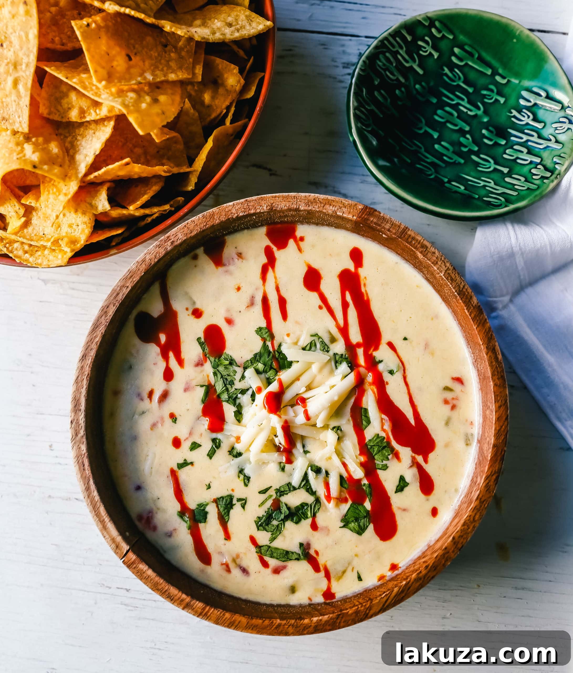 Homemade green chile queso dip, featuring a delectable blend of melted cheeses, spicy green chiles, fresh cilantro, and your favorite hot sauce. Perfect for Cinco de Mayo or any Mexican food celebration! #queso #cheesedip #appetizer #easyrecipe #mexican
