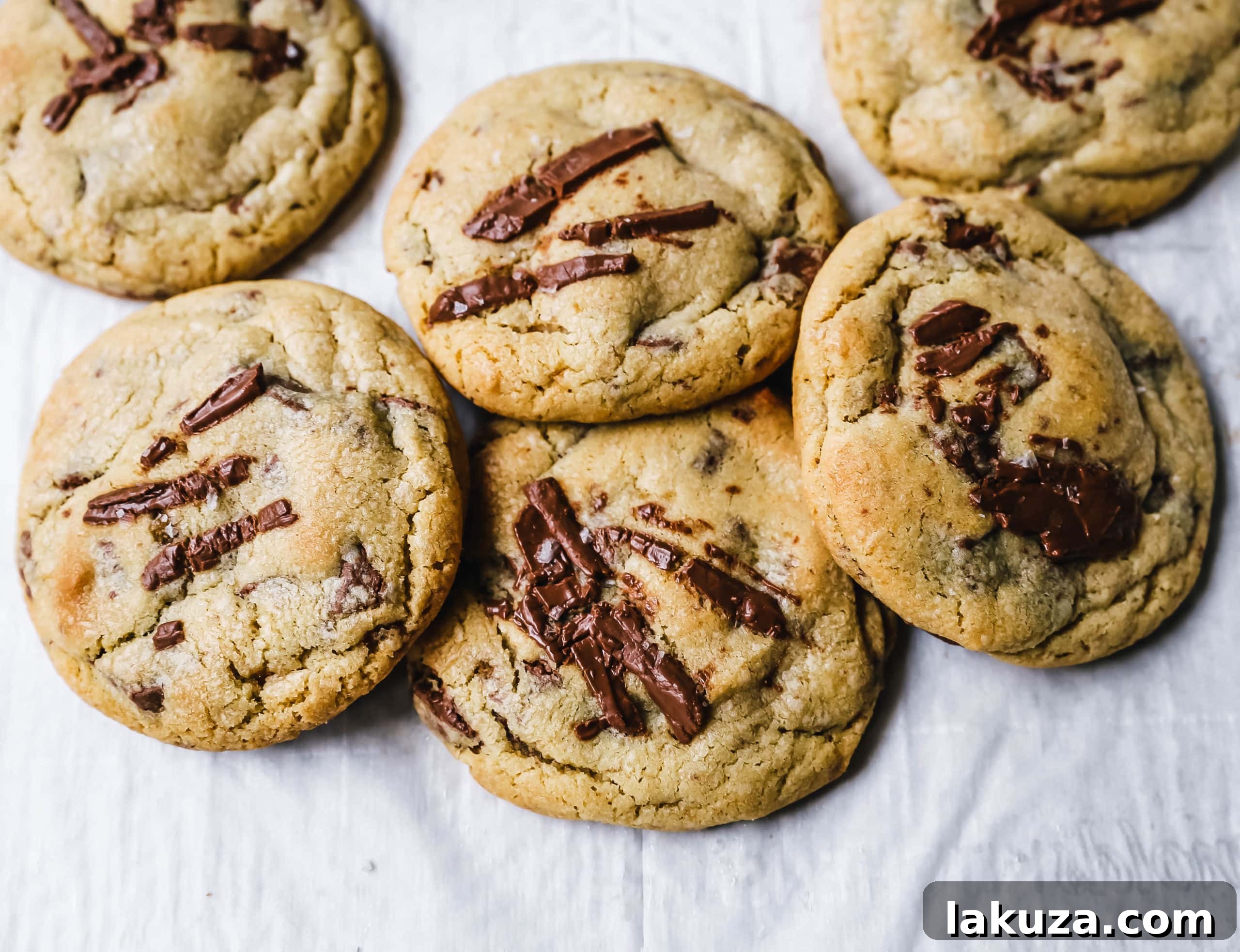 Close-up of chocolate chunks being folded into classic chocolate chip cookie dough in a mixing bowl.