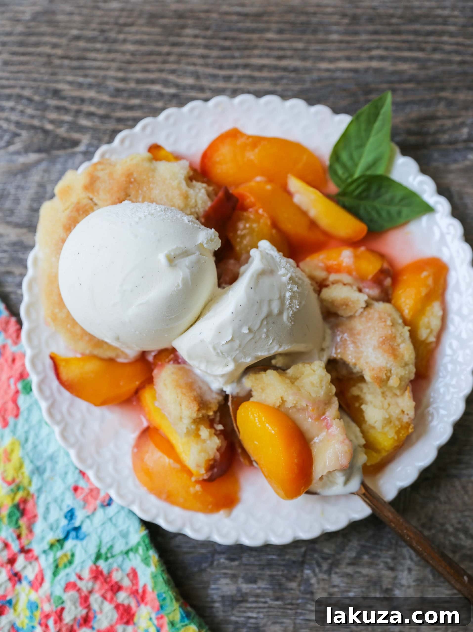 The Best Peach Cobbler Recipe! Fresh peaches tossed with a touch of sugar and topped with a homemade sweet and buttery topping that resembles a mix of a sugar cookie and a sweet biscuit.