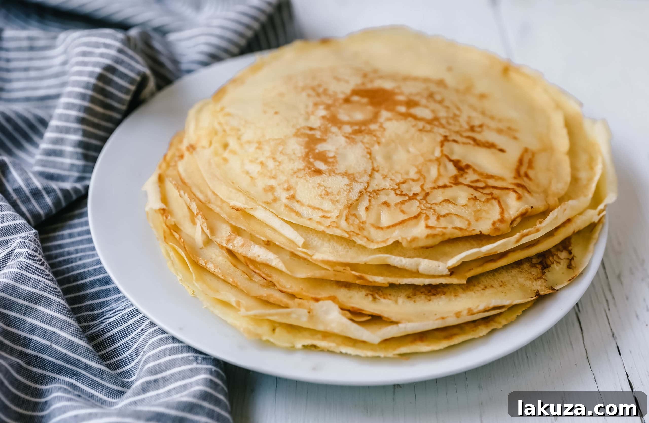Delicious homemade crepe being folded on a plate, ready to be served.
