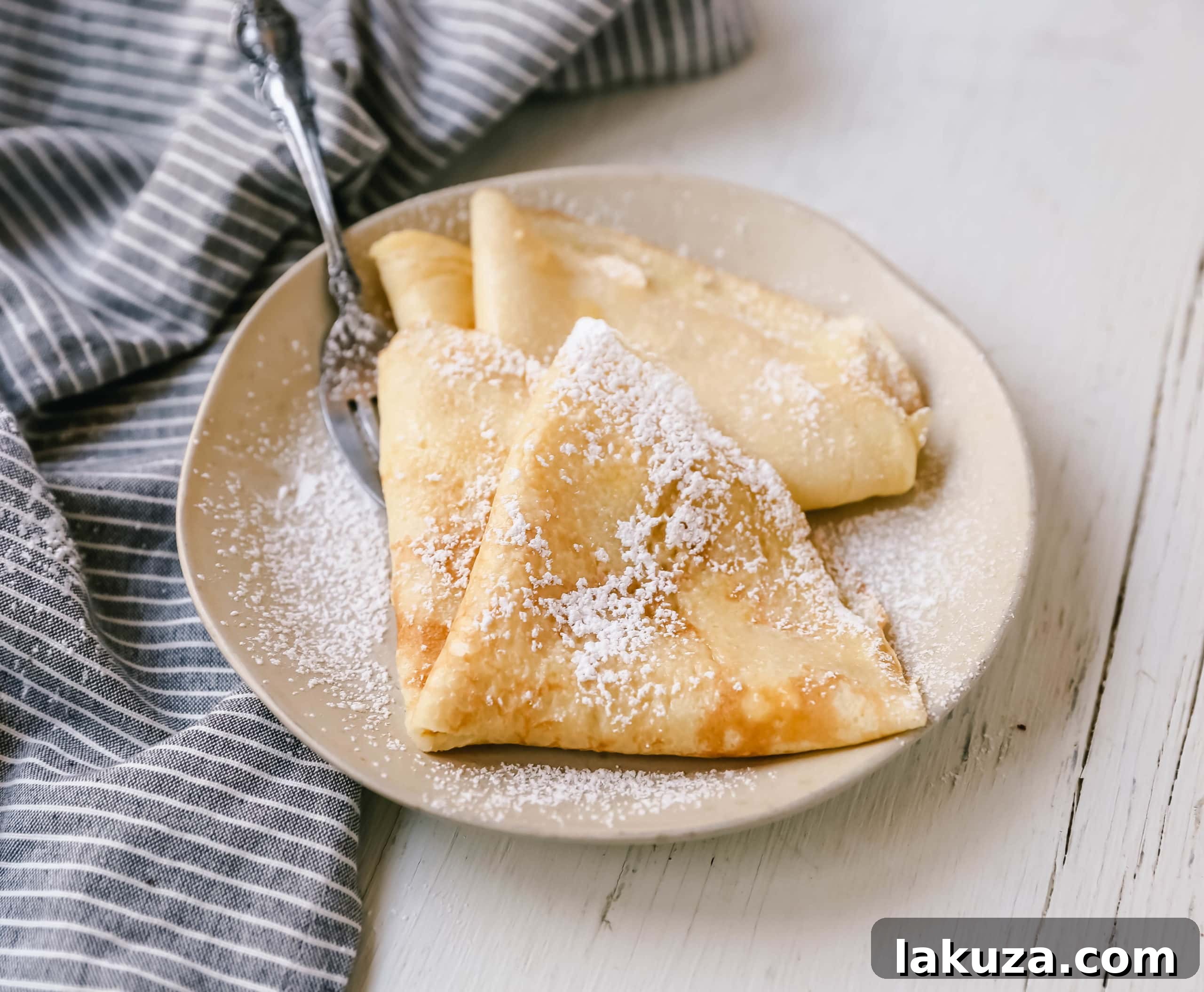 Close-up of a crepe filled with berries and whipped cream, ready to eat.