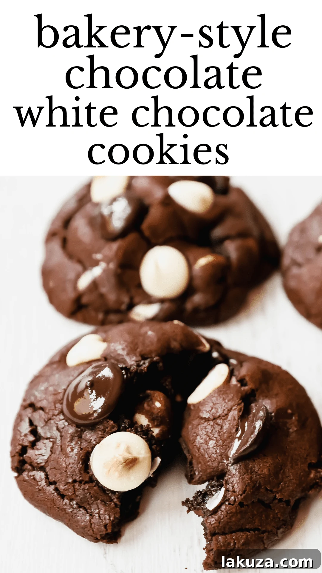 Vertical shot of a hand breaking apart a soft, warm Bakery-Style Chocolate White Chocolate Chip Cookie.