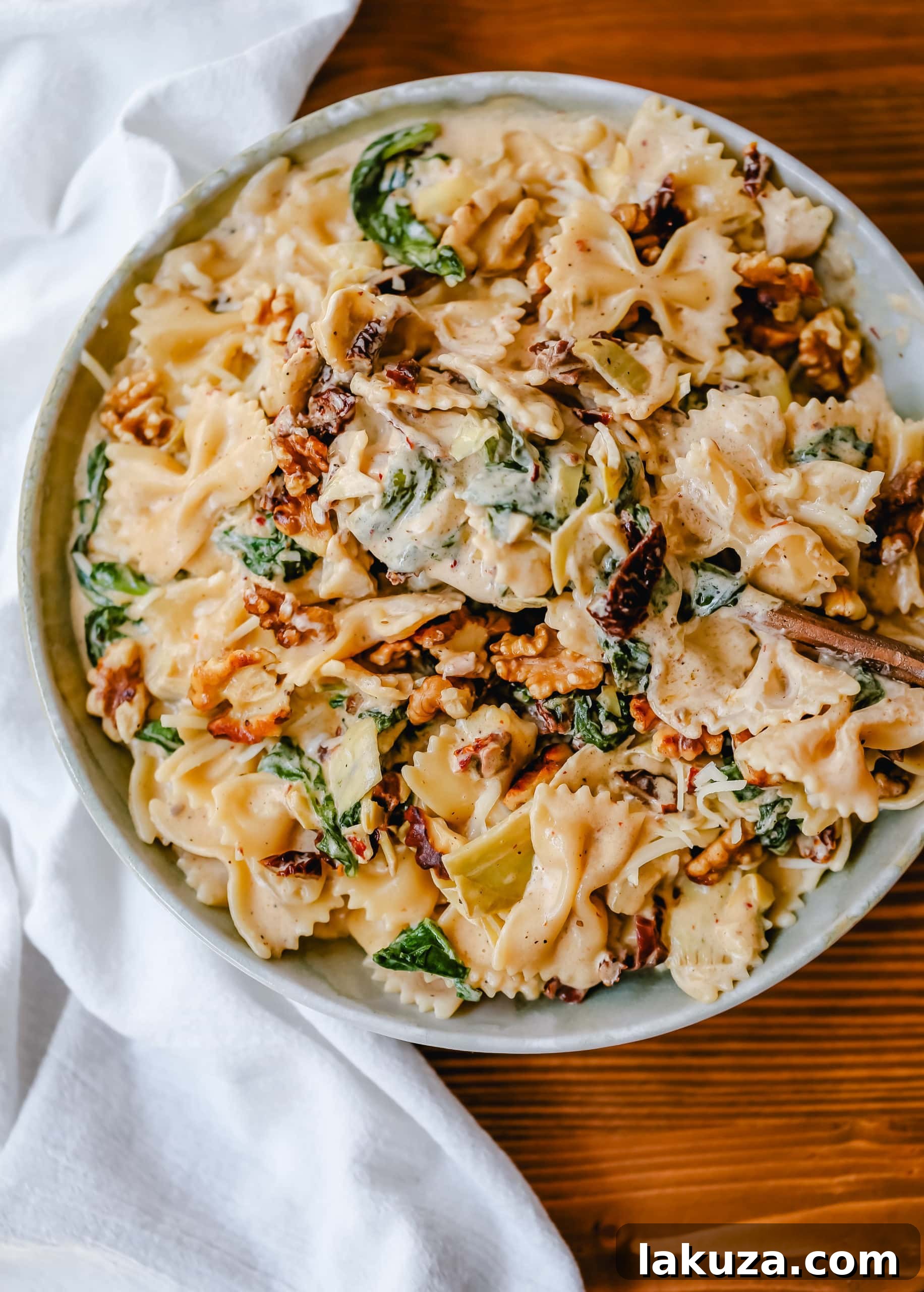 Tuscan Sun-Dried Tomato Cream Farfalle 2 Creamy Bowtie Pasta with Sundried Tomatoes, a quick 20-minute weeknight meal featuring farfalle pasta, a rich garlic cream sauce, sundried tomatoes, artichoke hearts, and toasted walnuts.
