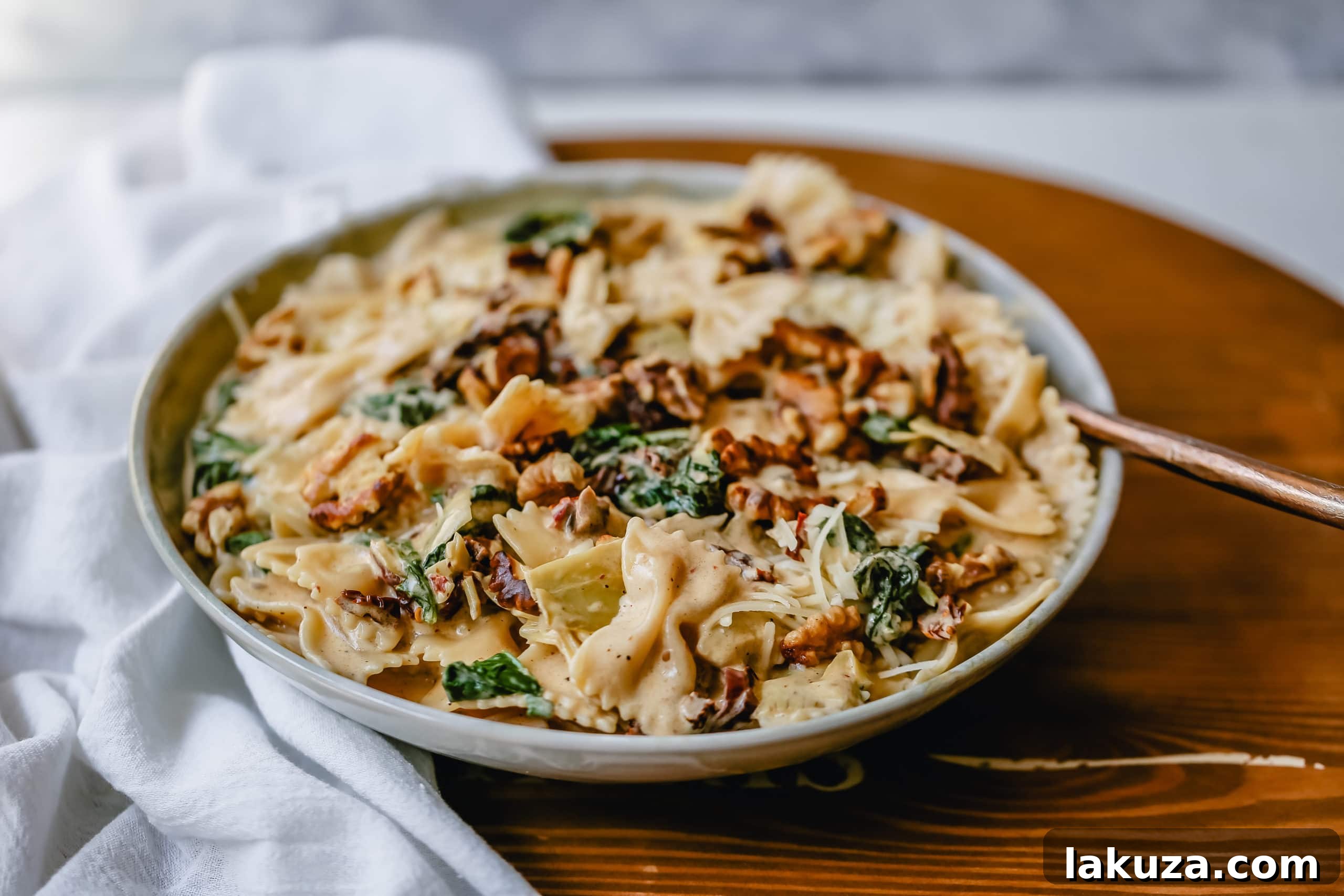Tuscan Sun-Dried Tomato Cream Farfalle 4 Ingredients laid out for Creamy Bowtie Pasta with Sundried Tomatoes, including farfalle, sundried tomatoes, artichoke hearts, spinach, and grated Parmesan cheese.