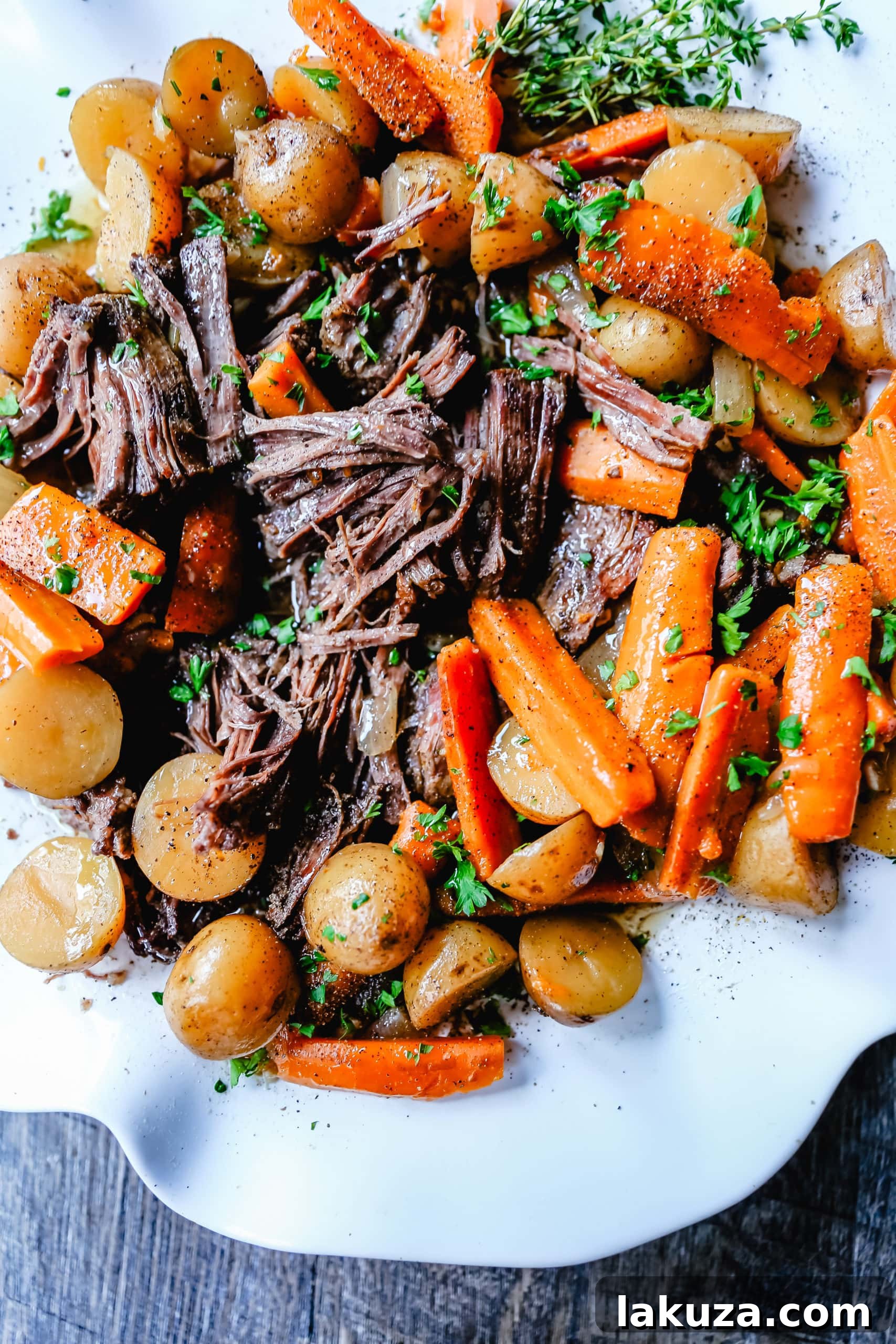 A close-up of a succulent beef pot roast, slow-cooked with tender Yukon gold potatoes and carrots, soaking in rich gravy.