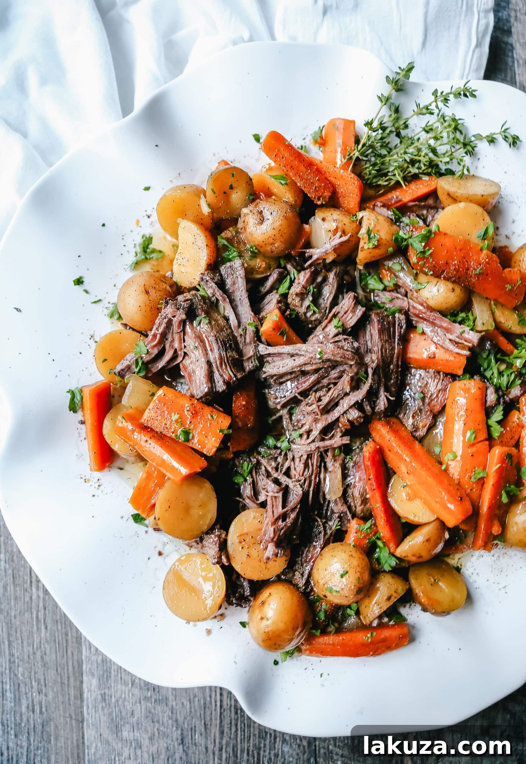 A vibrant display of fresh carrots, onions, Yukon gold potatoes, and garlic, essential ingredients for a hearty beef pot roast.
